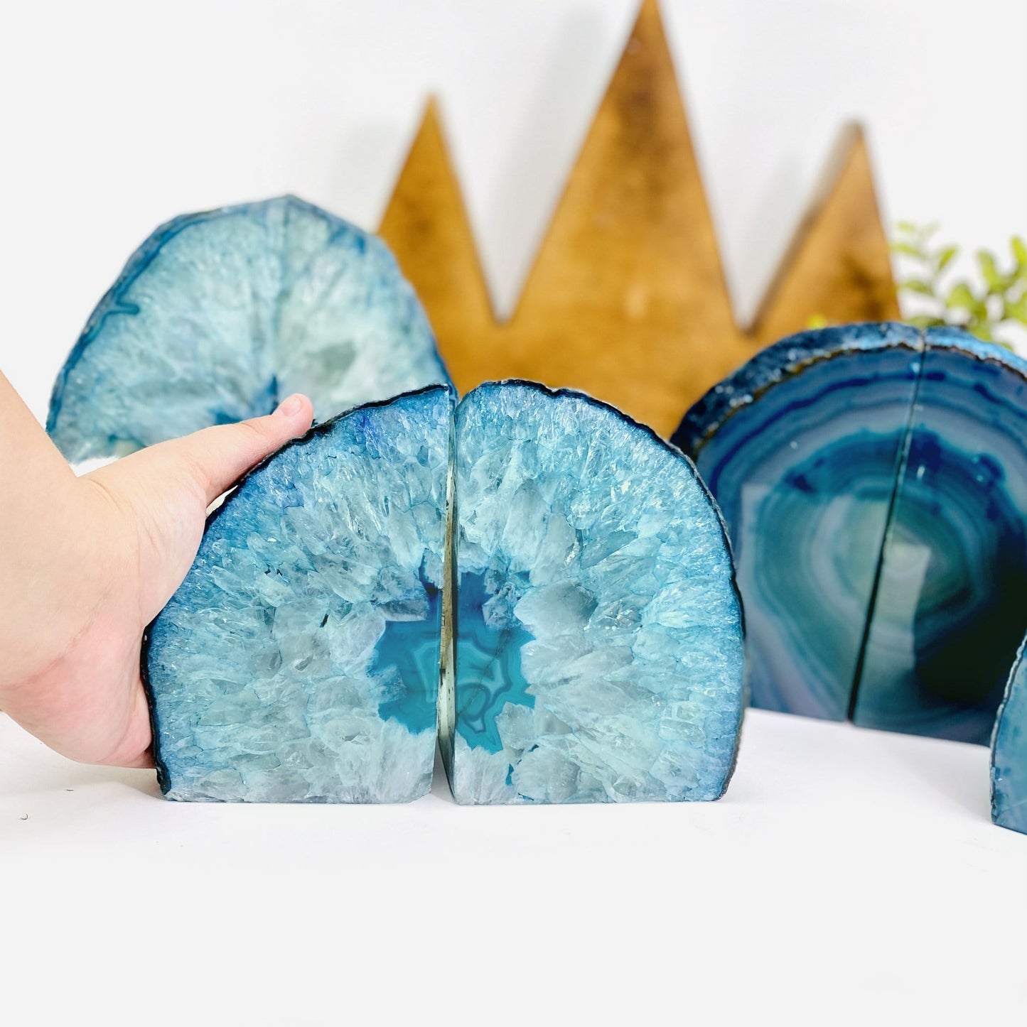 Teal Agate Bookend Pair shown front facing and a hand.
