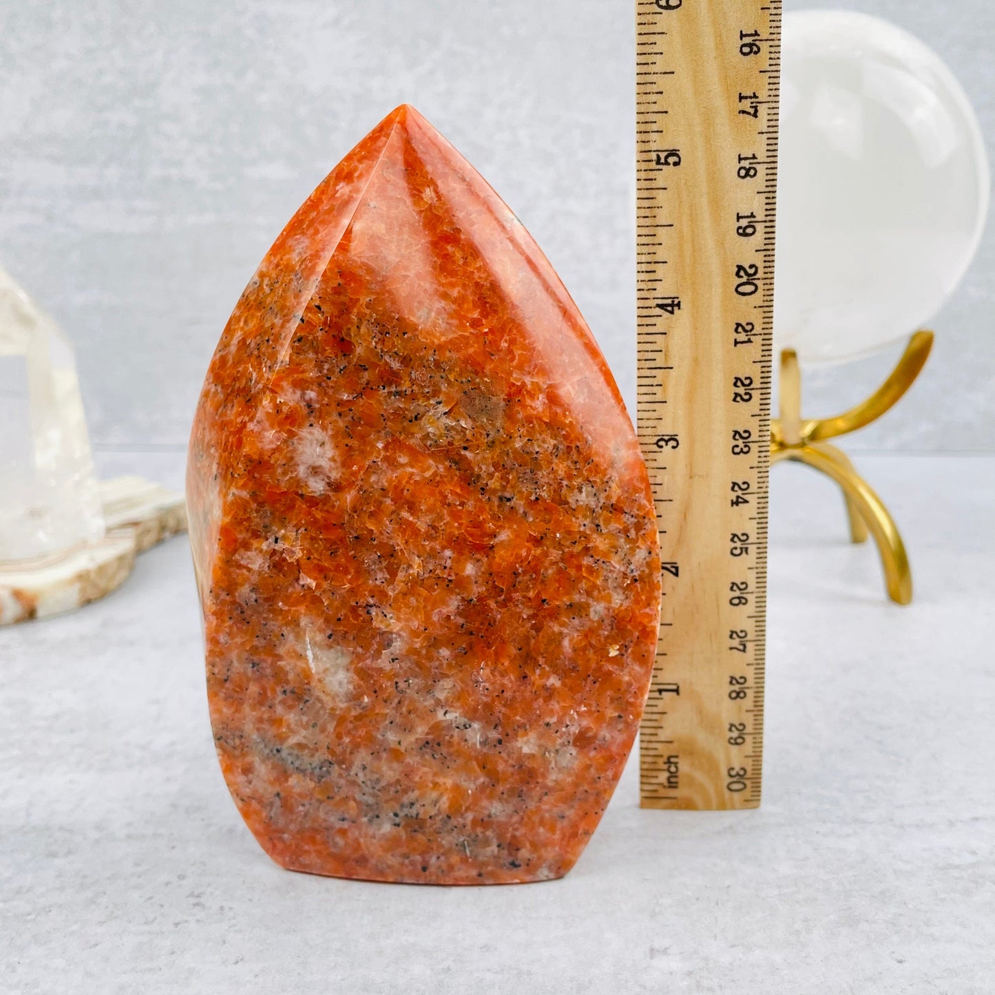 orchid calcite flame tower next to a ruler for size reference