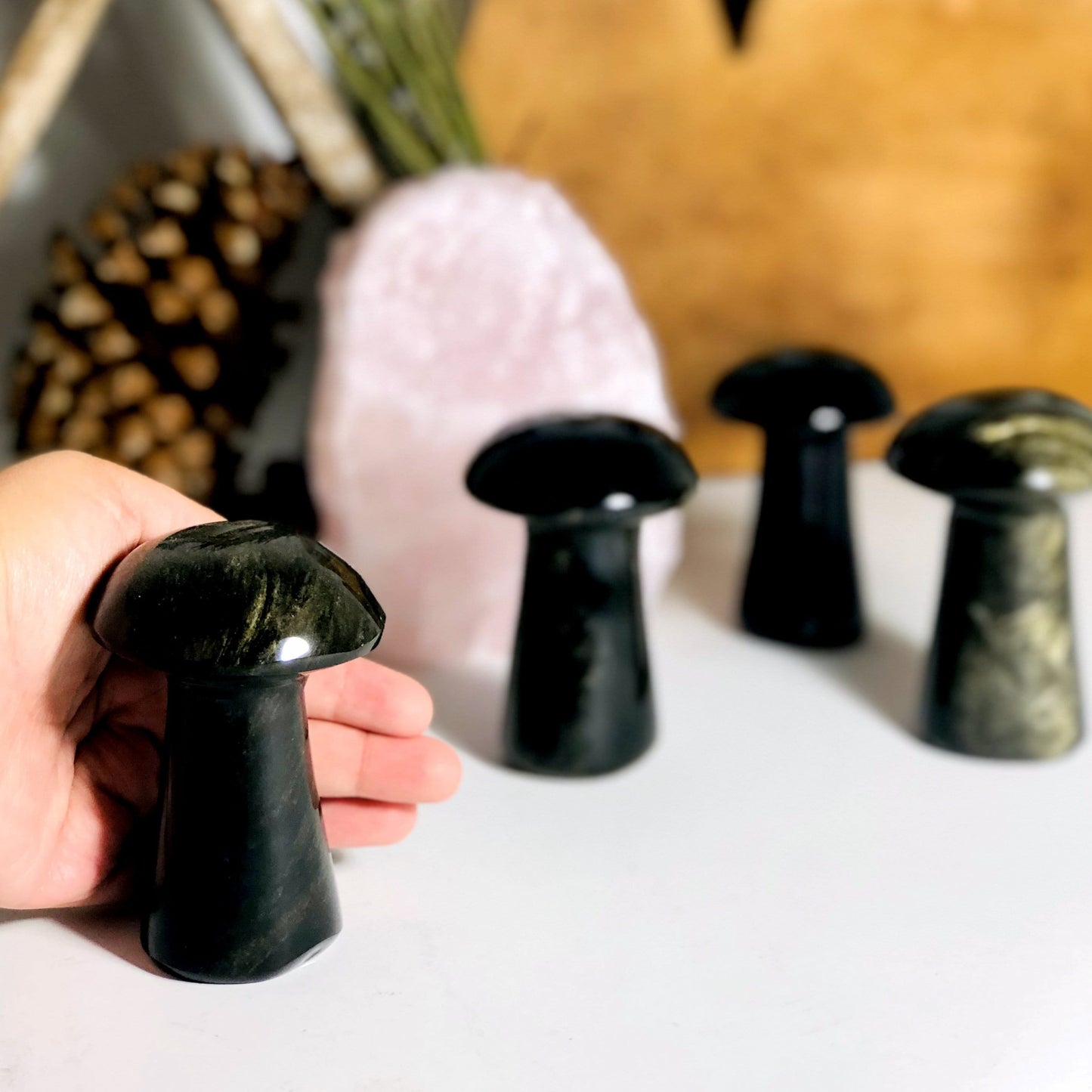 Gold Sheen Obsidian Polished Mushroom displayed by hand for size and thickness reference