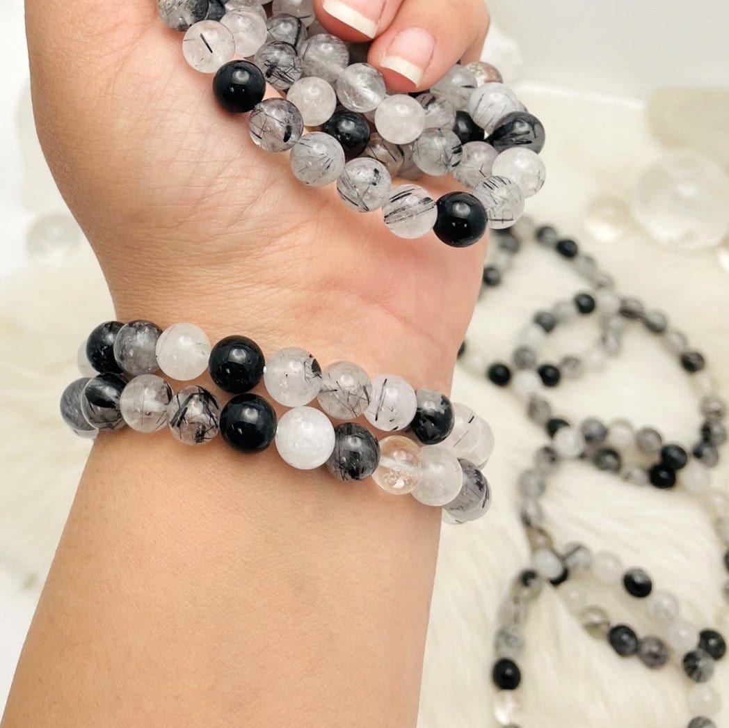 Black Rutilated Round Bead Bracelets - 2 on an arm and a few in the hand
