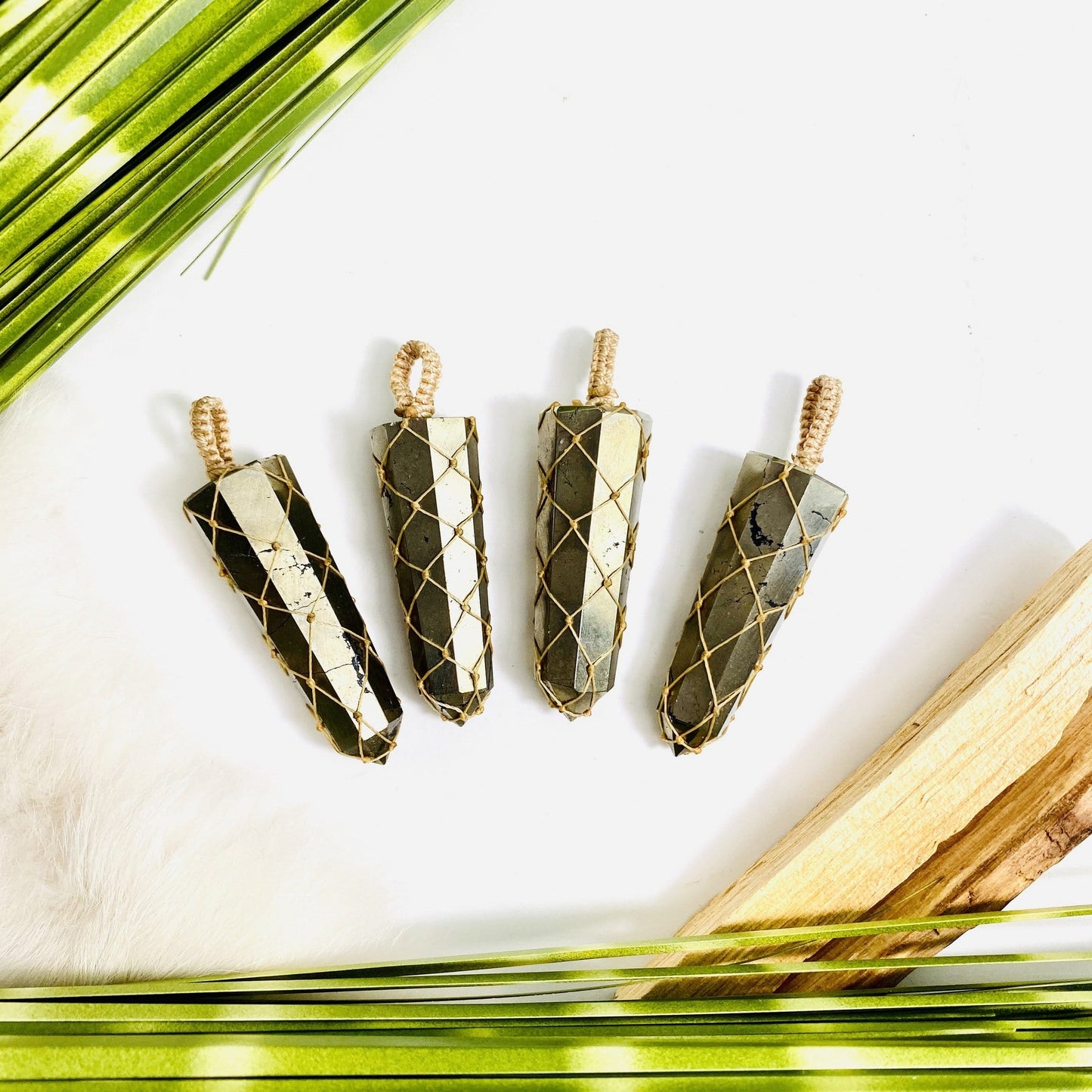 4 netted pyrite pendants on a table