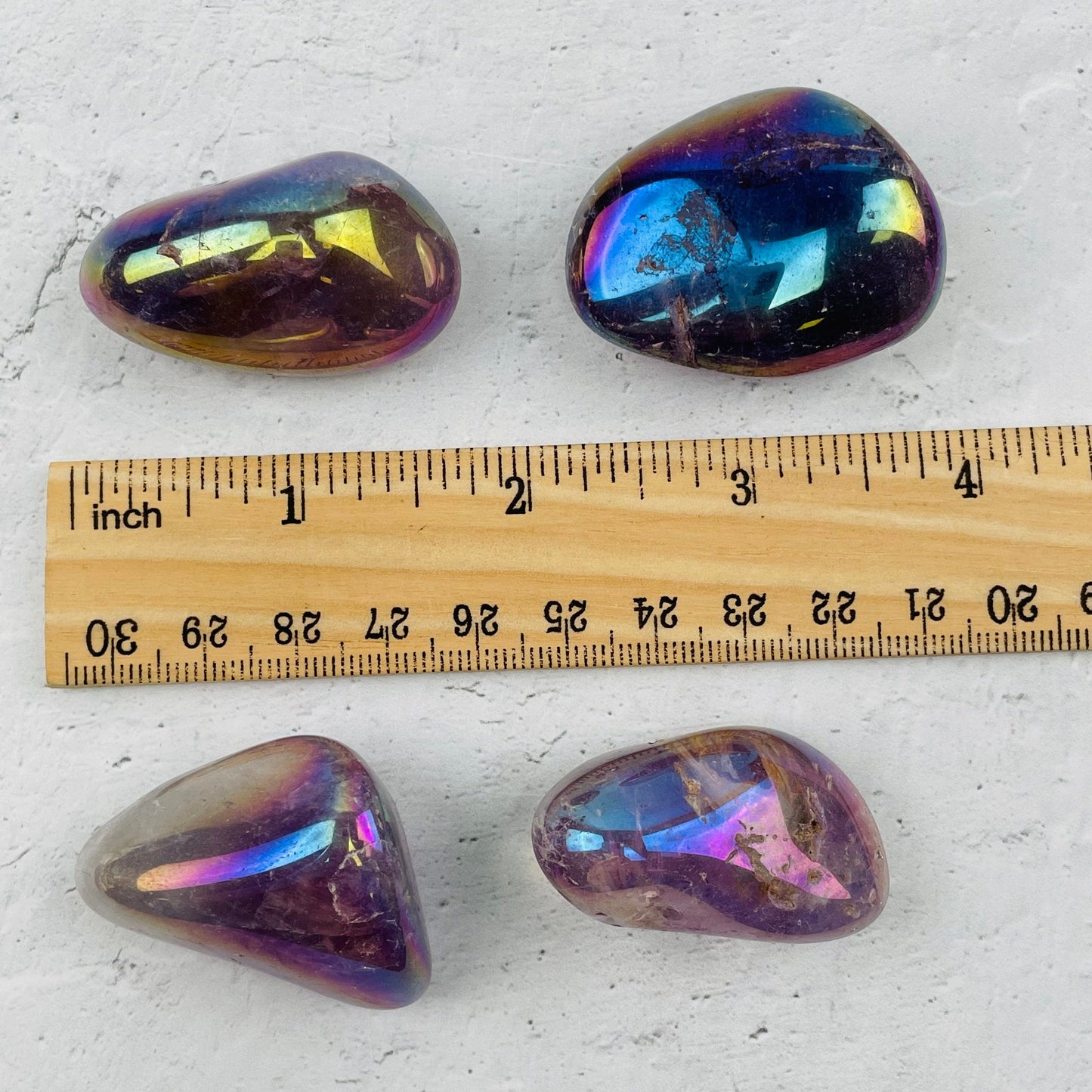 tumbled stones next to a ruler for size reference