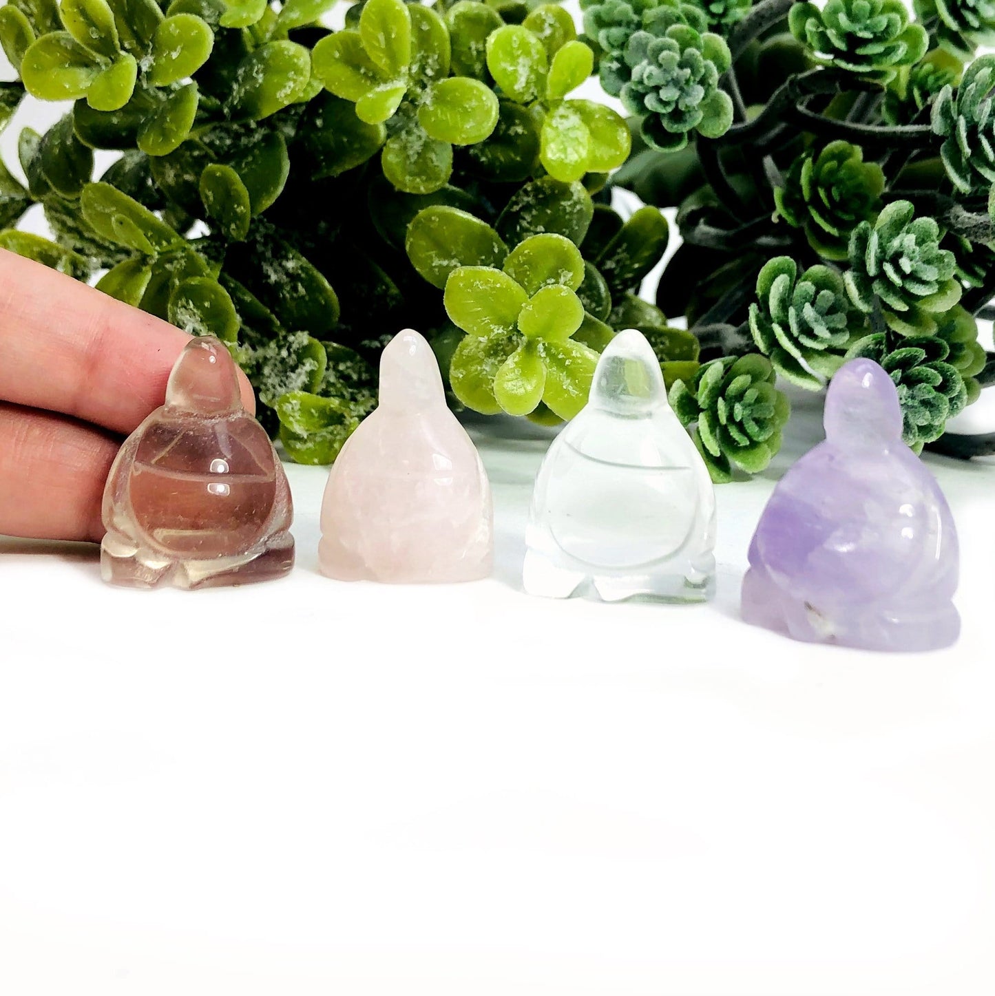 hand displayed next to buddha cabochons for size reference