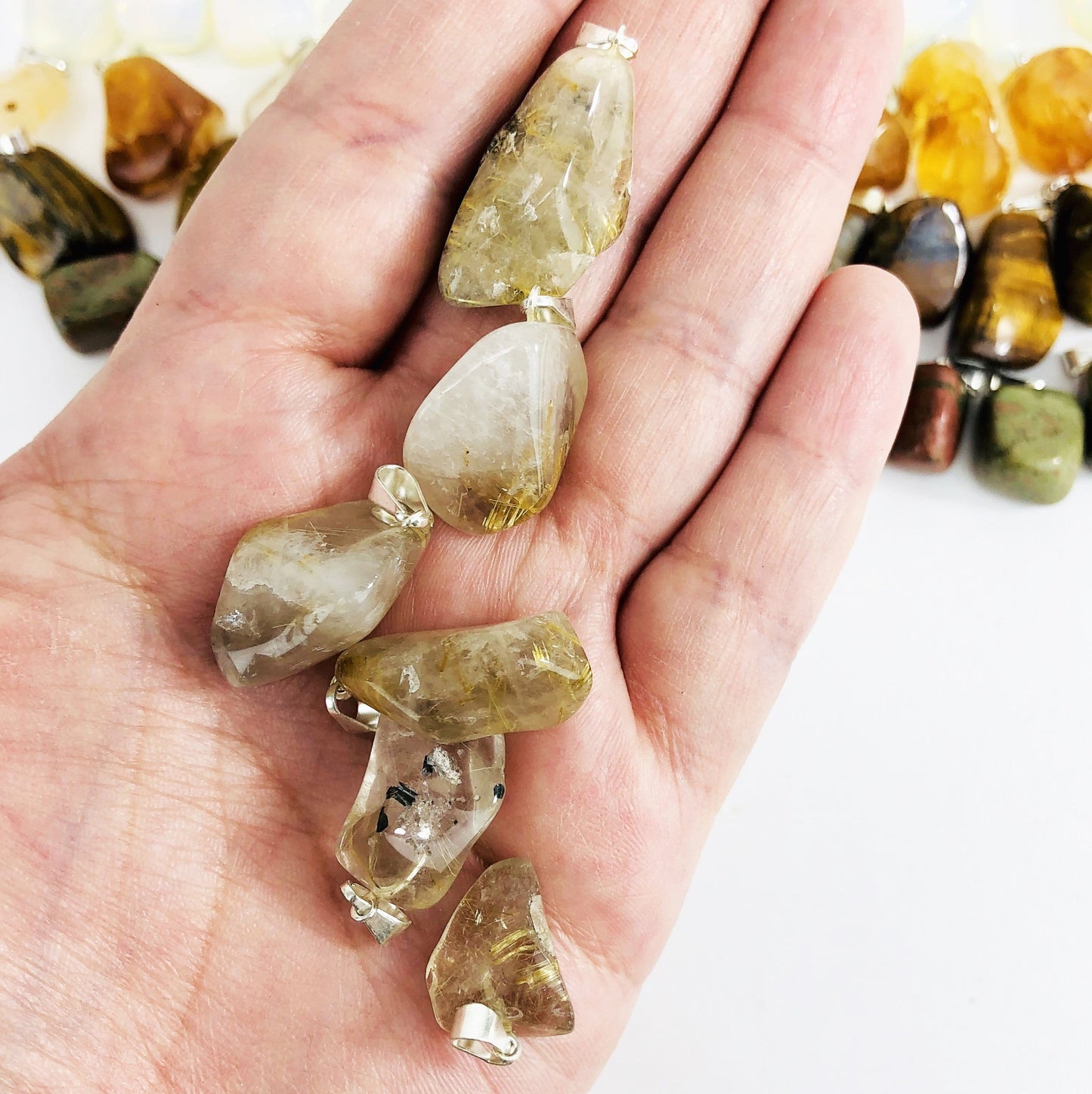 Tumbled Gemstone Extra Grade Pendants, displayed in hand