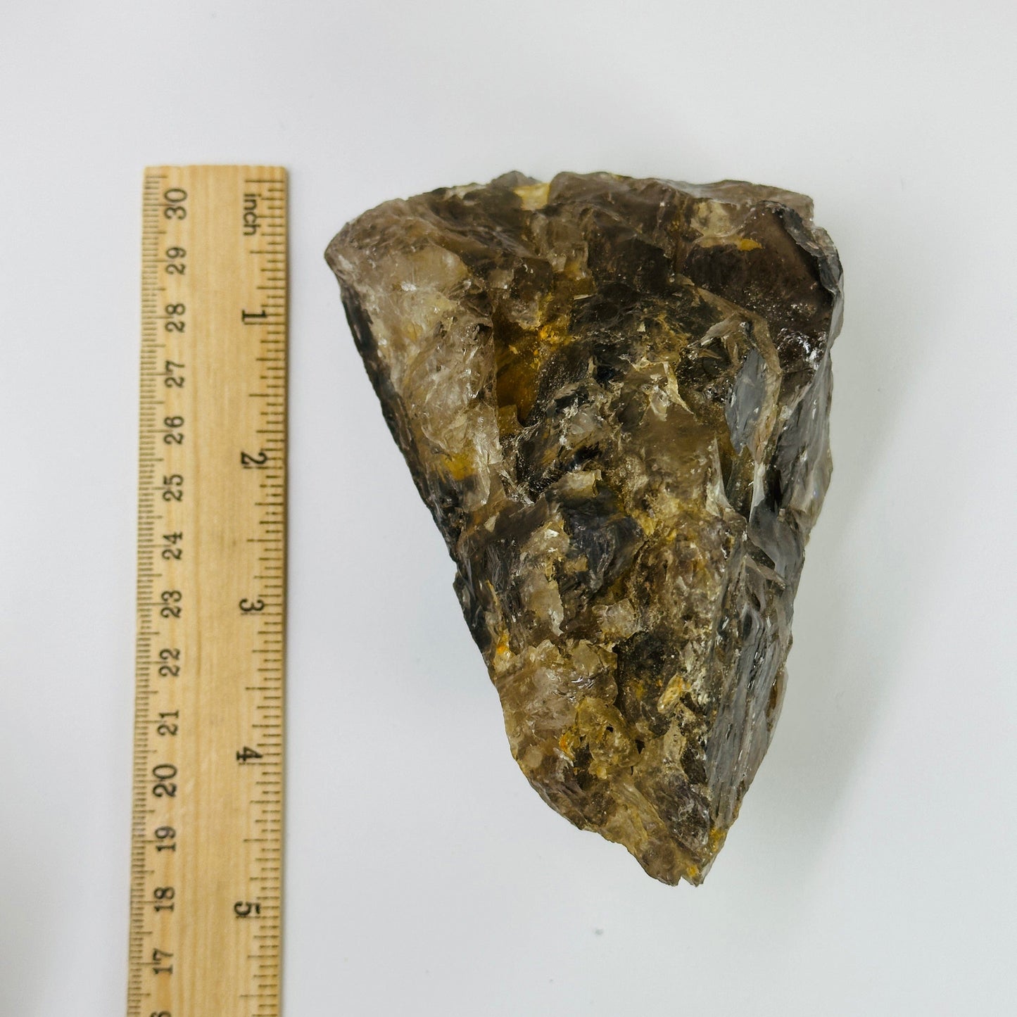smoky quartz cluster next to a ruler for size reference
