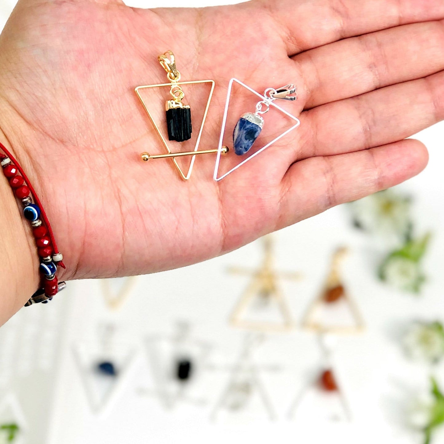 Gold and Silver element pendants on a hand