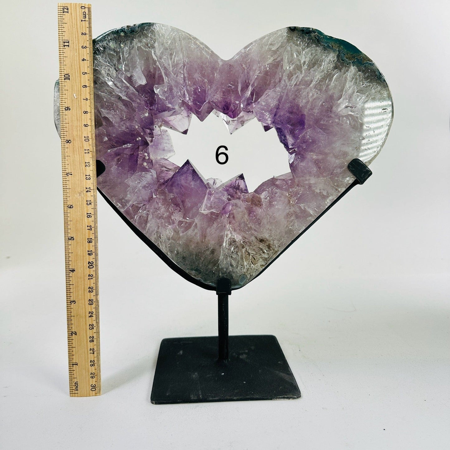 amethyst heart on stand next to a ruler for size reference