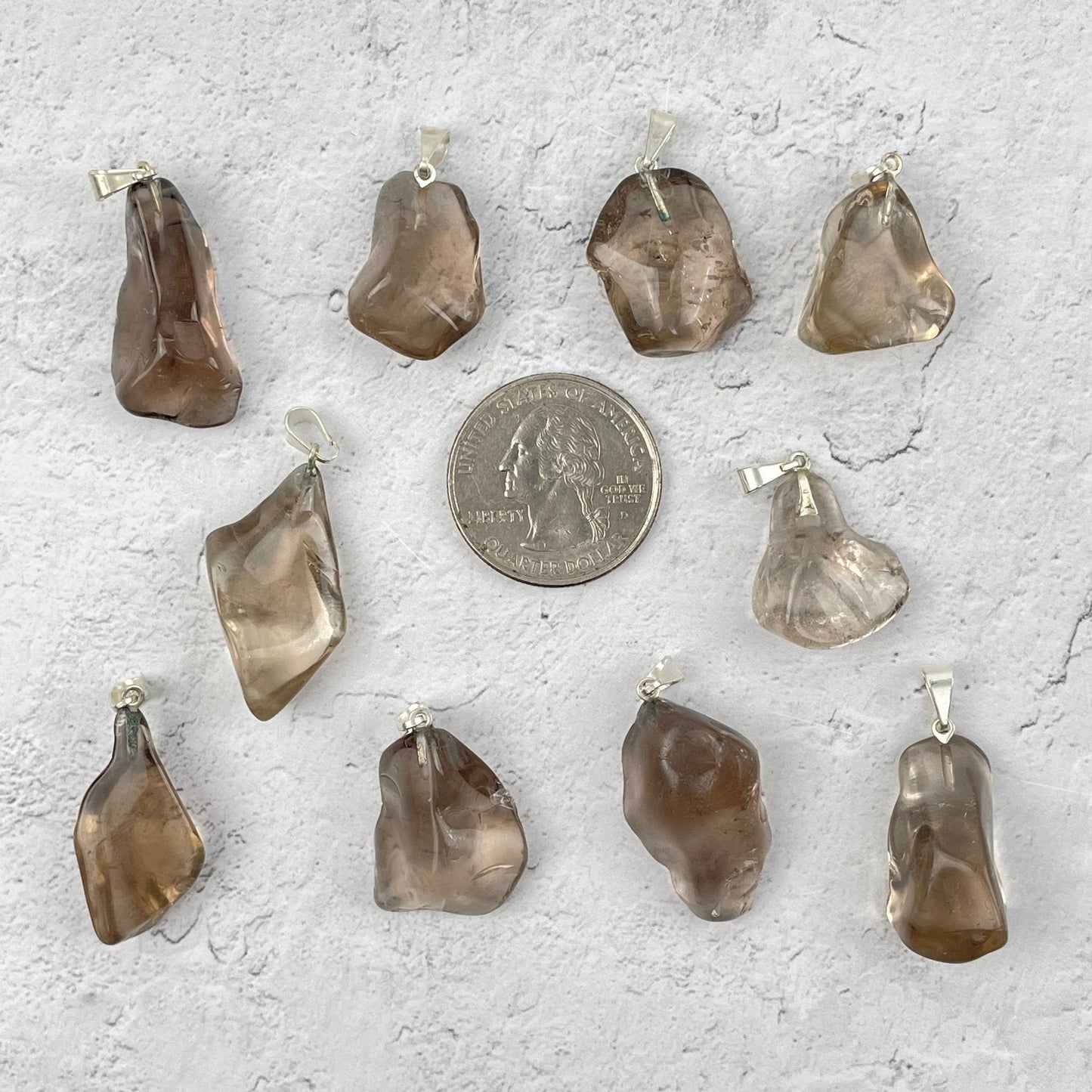 pendants next to a quarter for size reference