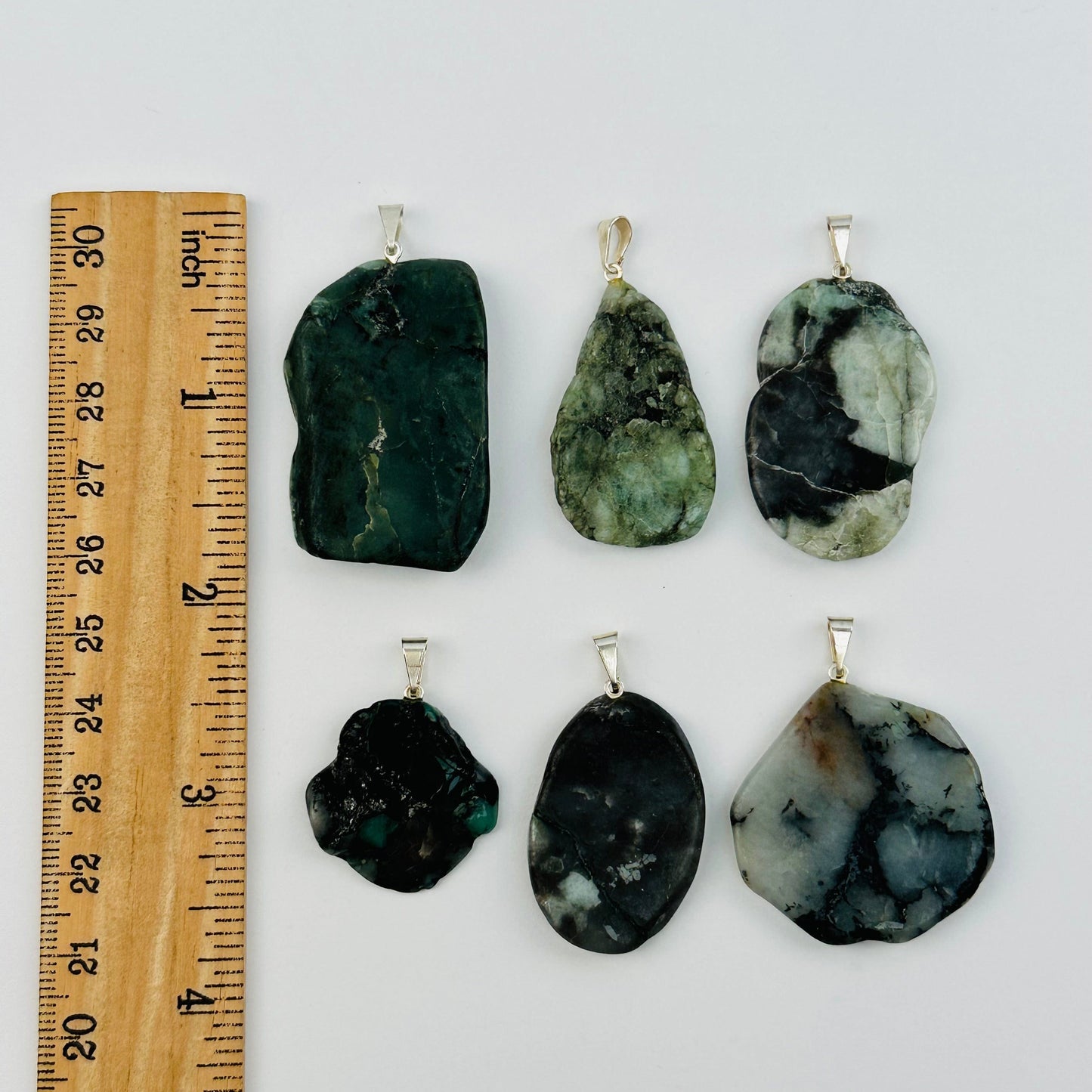 pendants next to a ruler for size reference