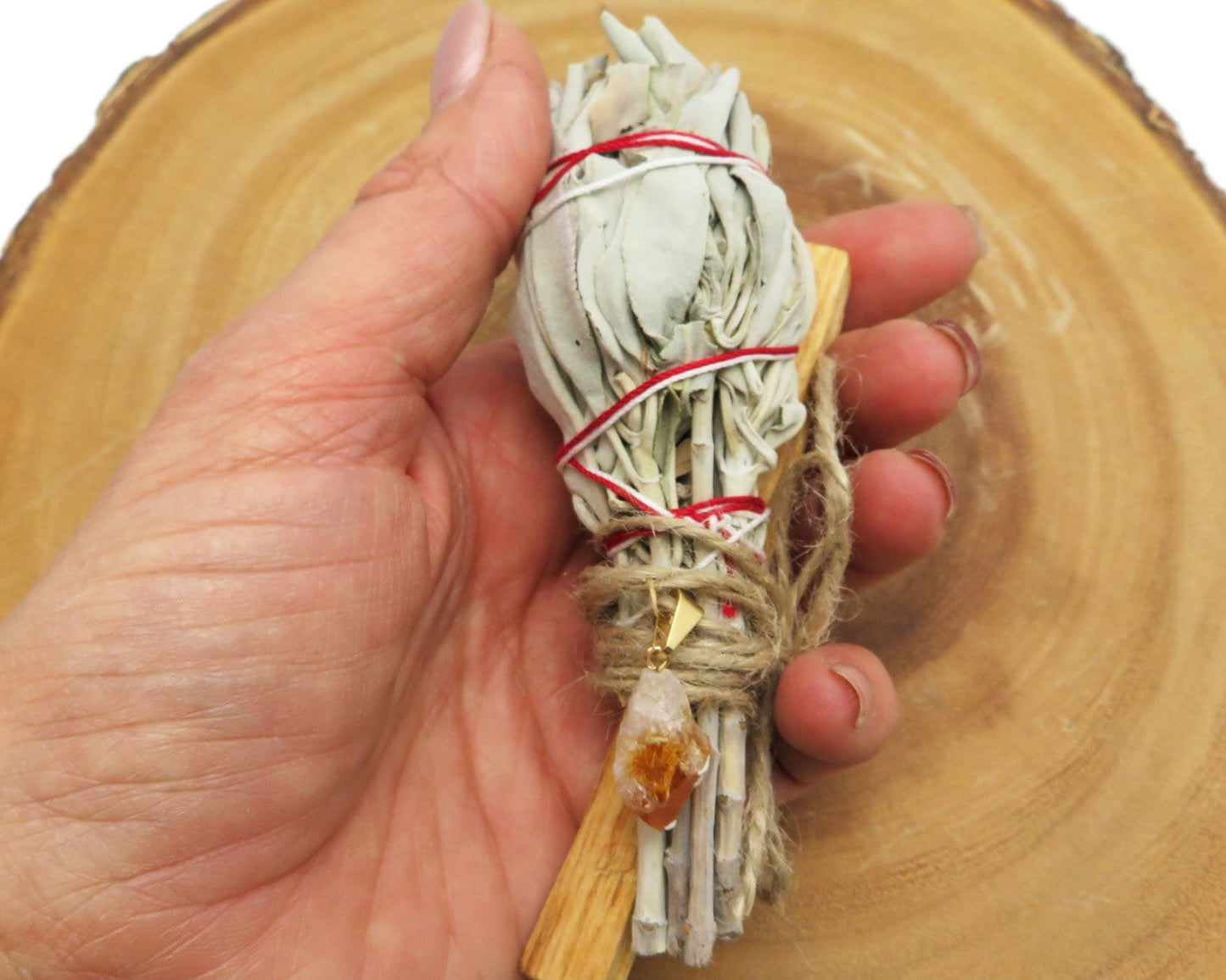 close up of sage palo santo bundle with citrine pendant for size reference and possible variations