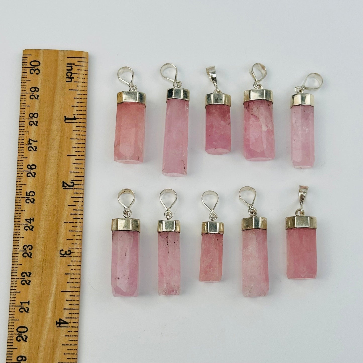 pendants next to a ruler for size reference