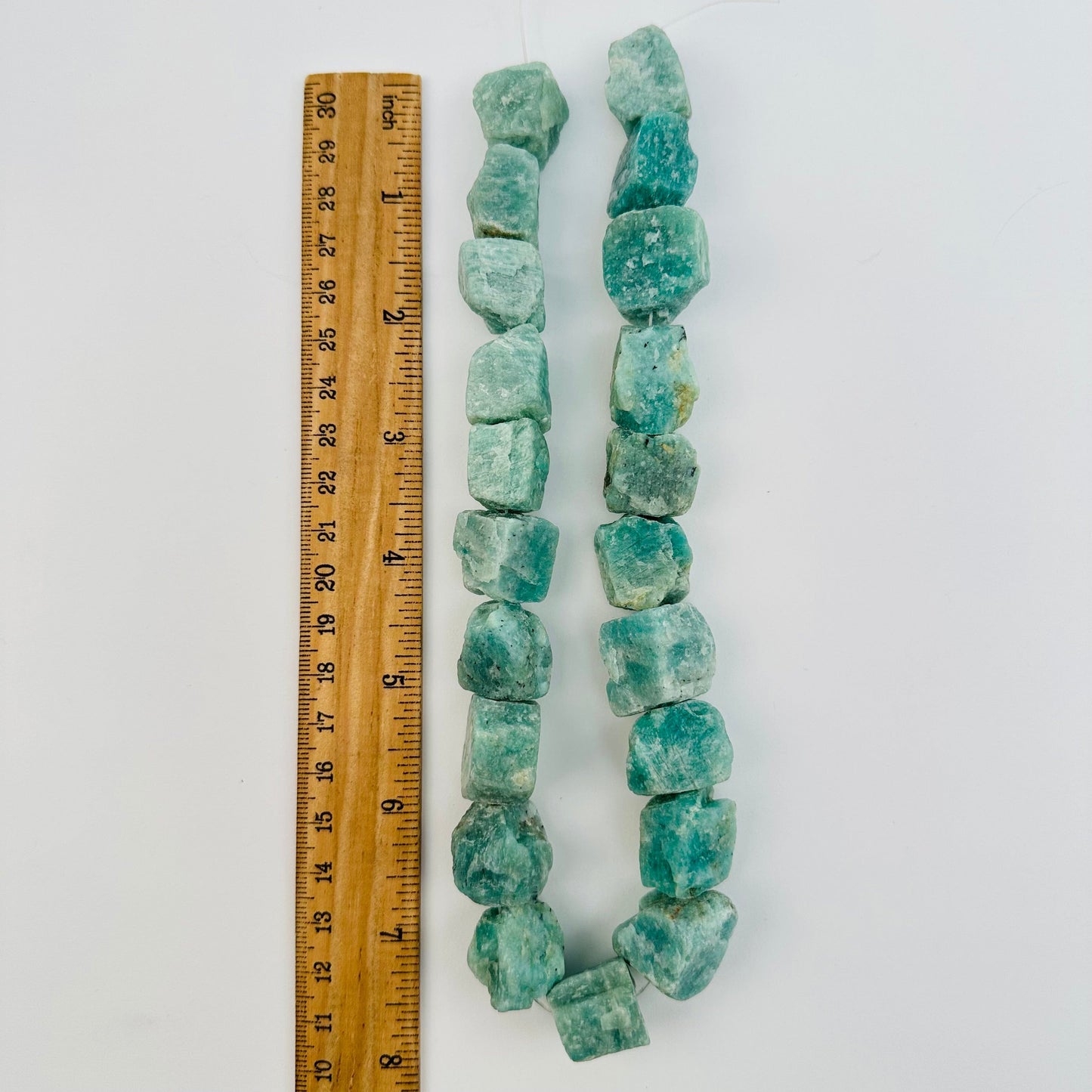 amazonite crystal beads displayed next to a ruler for size reference