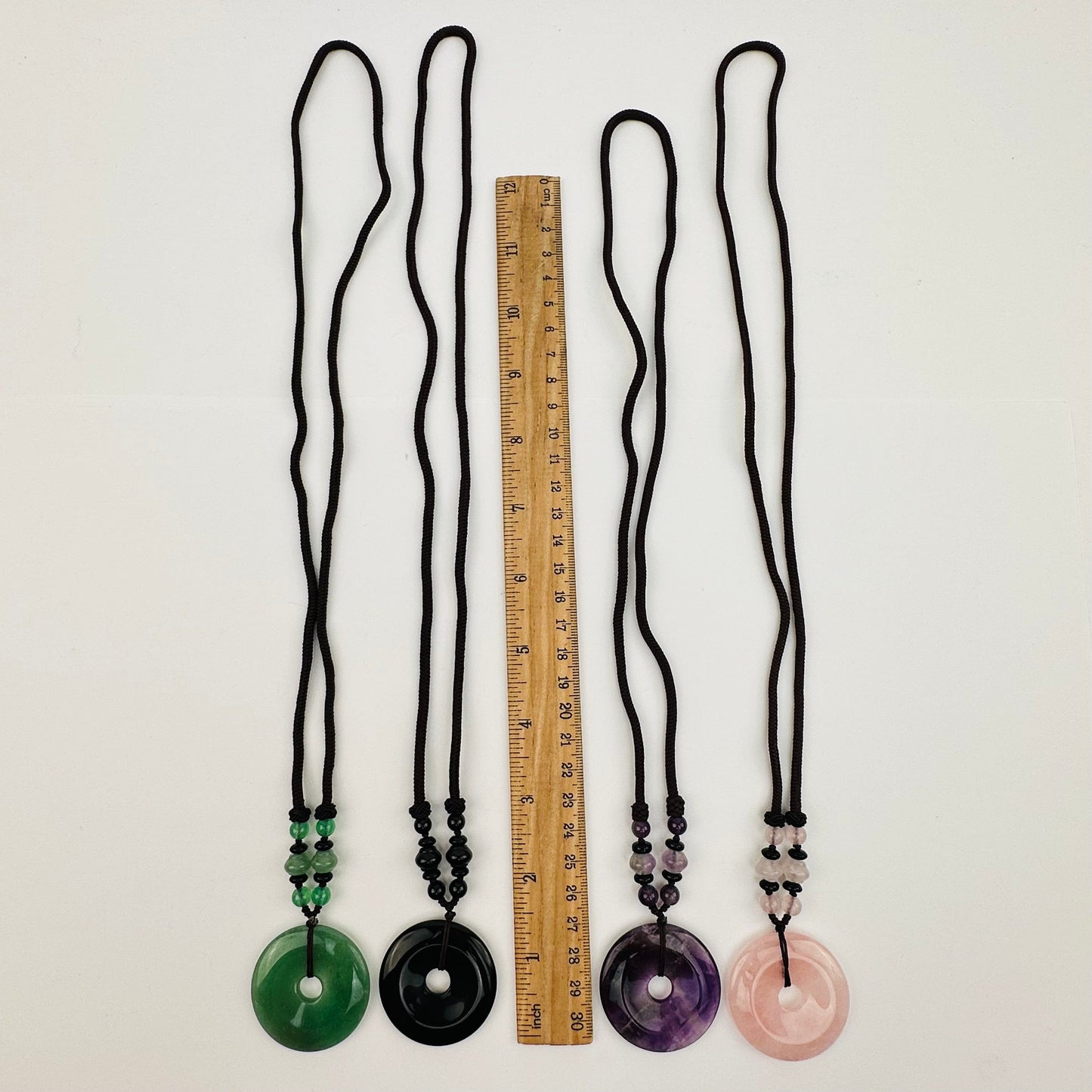 necklaces displayed next to a ruler for size reference