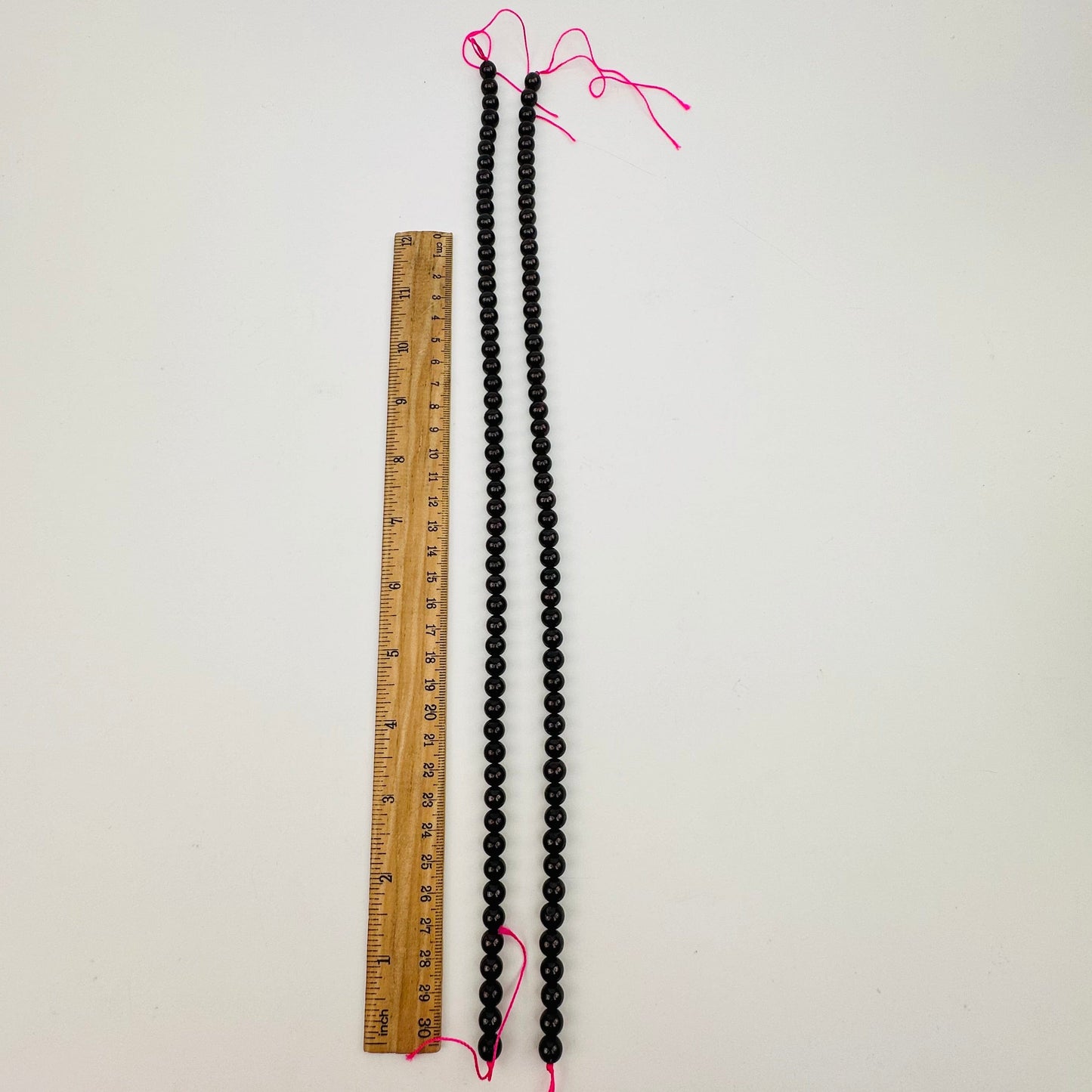 bead strands displayed next to a ruler for size reference