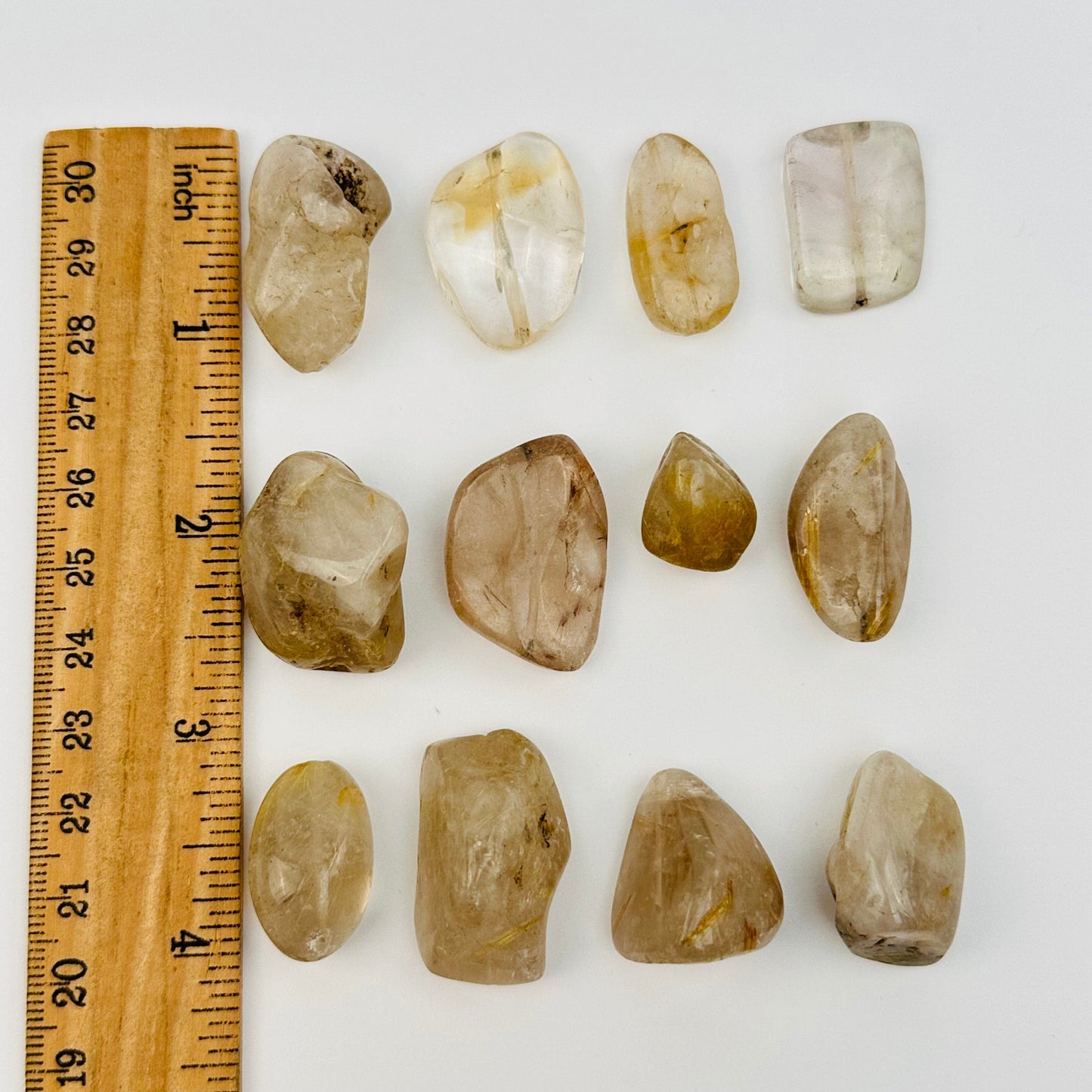 Rutilated Crystal Quartz Tumbled Beads displayed next to a ruler for size reference