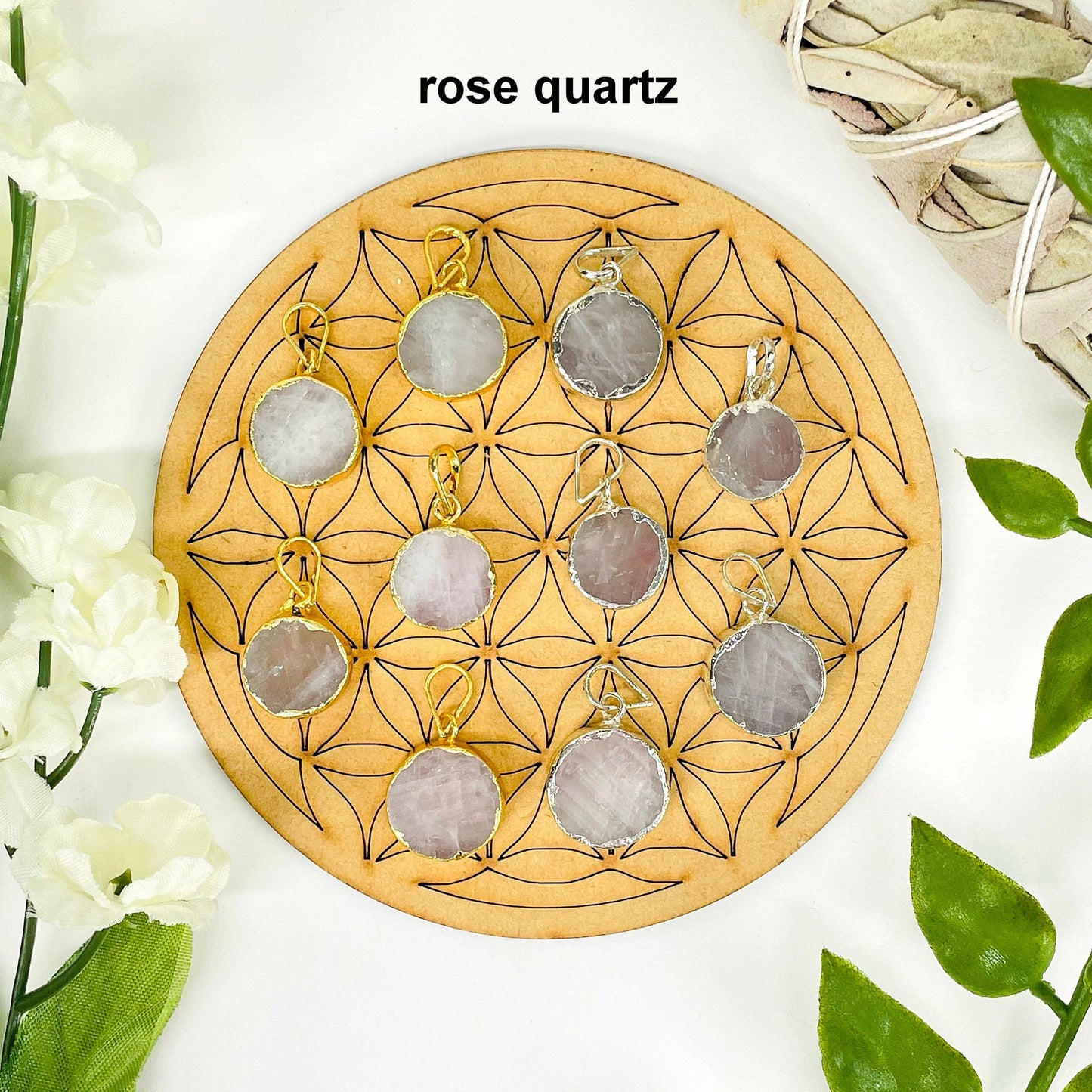 overhead view of five gold and five silver round rose quartz pendants on display with decorations for possible variations and finish comparison