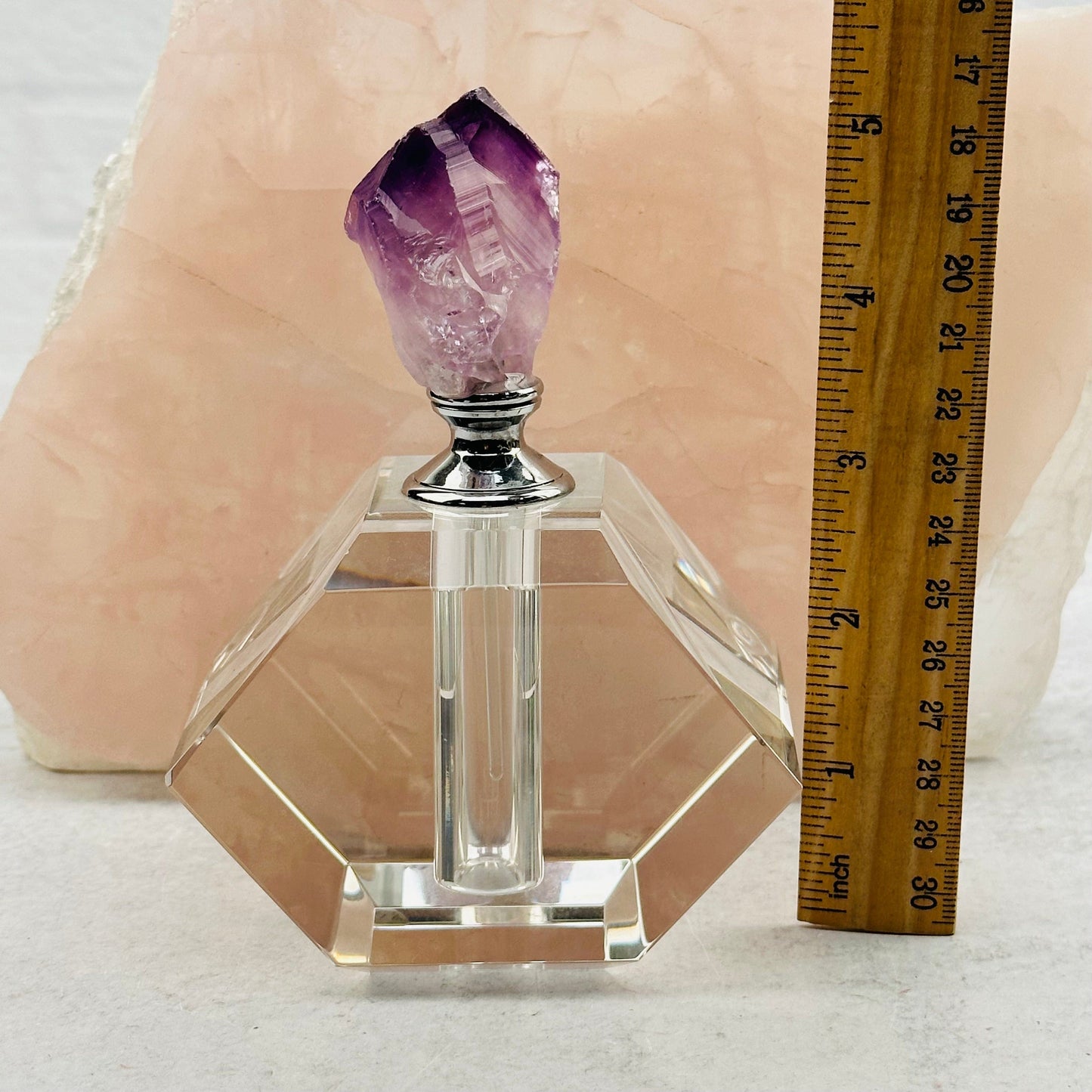 perfume bottle next to a ruler for size reference