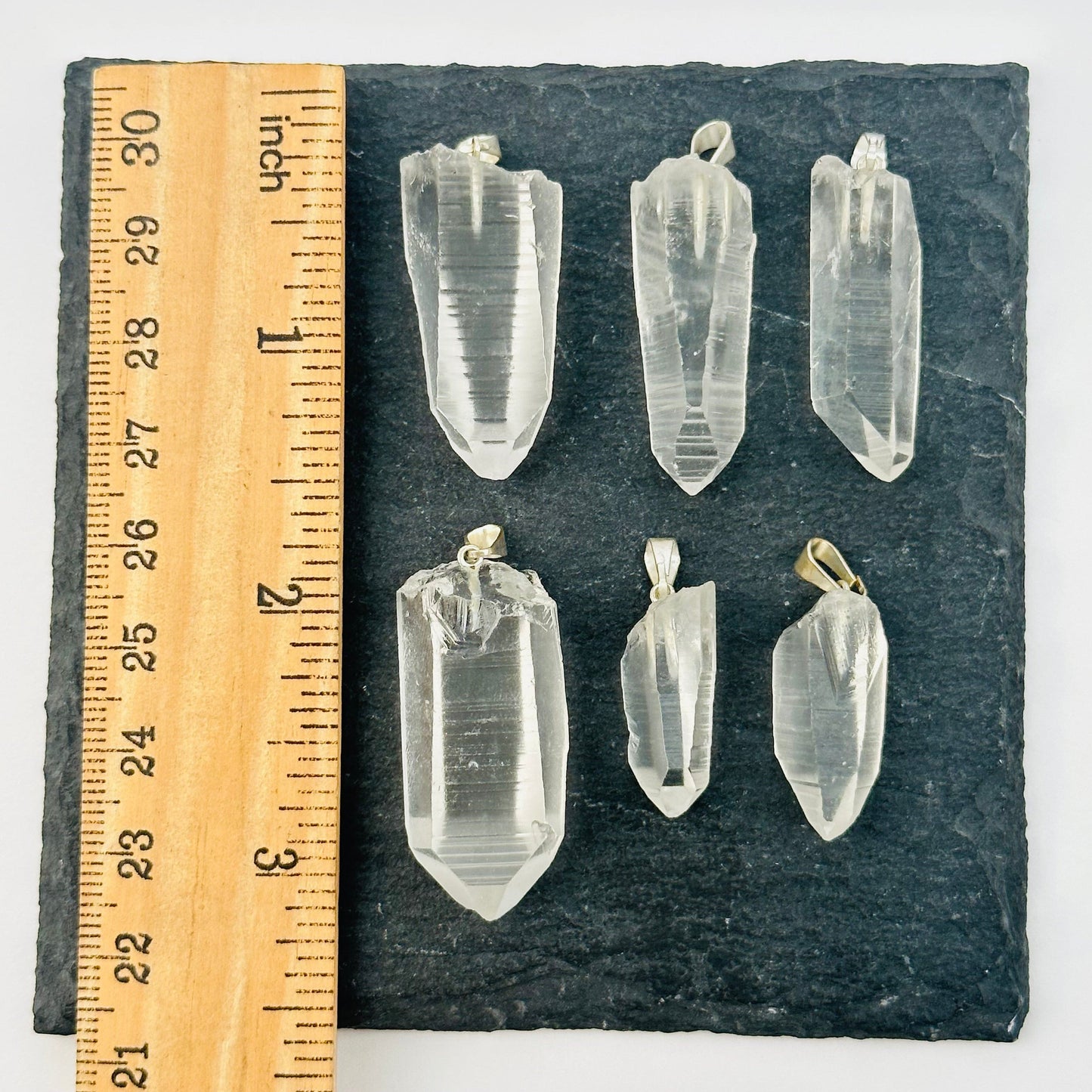 lemurian pendants next to a ruler for size reference