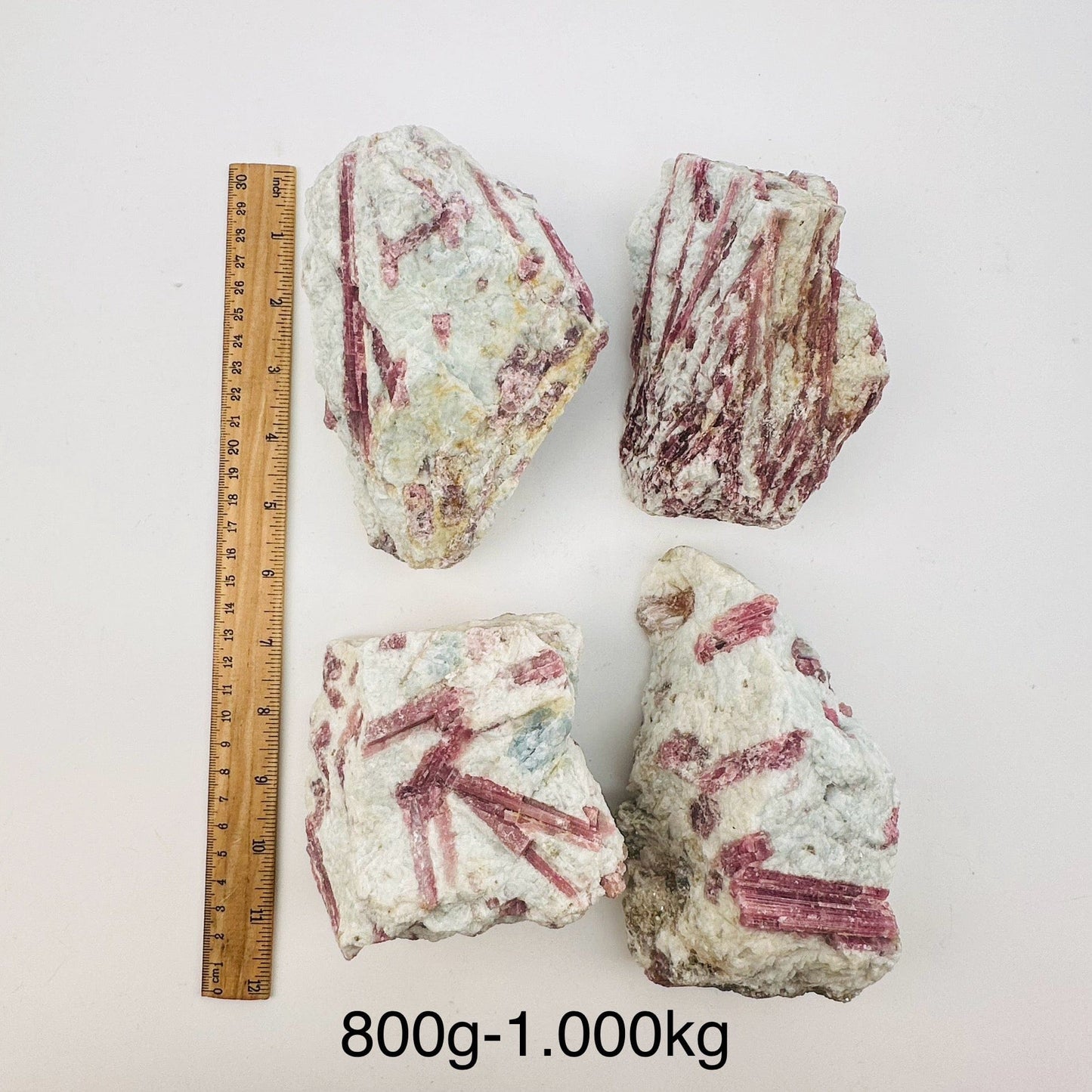 pink tourmaline crystal clusters sold by weight. displayed next to a ruler for size reference