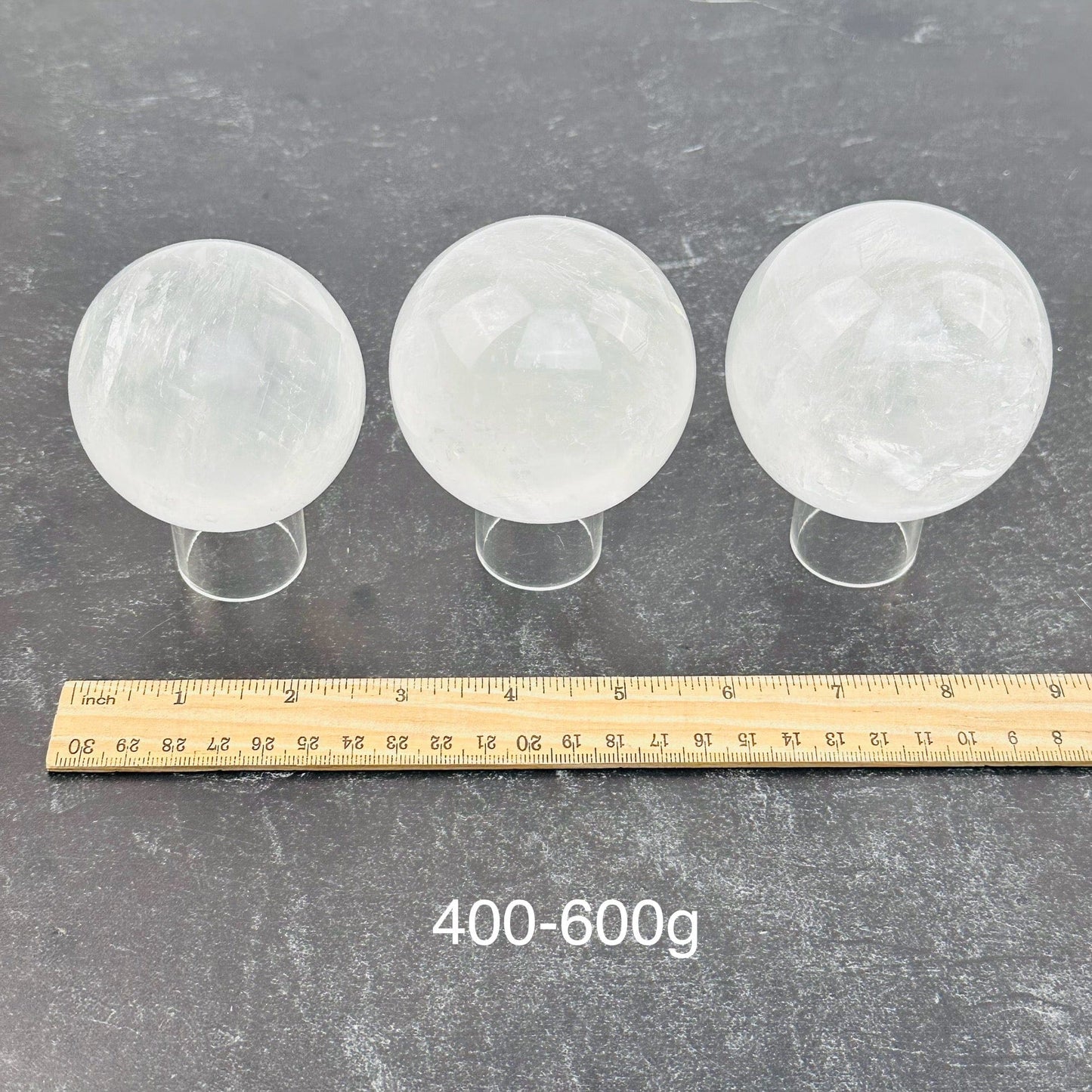 calcite crystal spheres sold by the weight. displayed next to a ruler for size reference