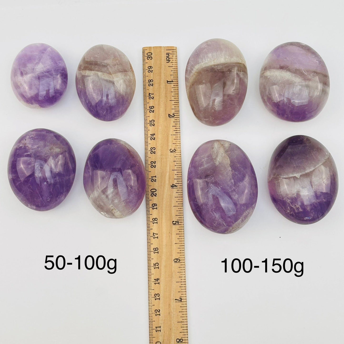 seven minerals in one crystal palm stones displayed next to a ruler for size reference