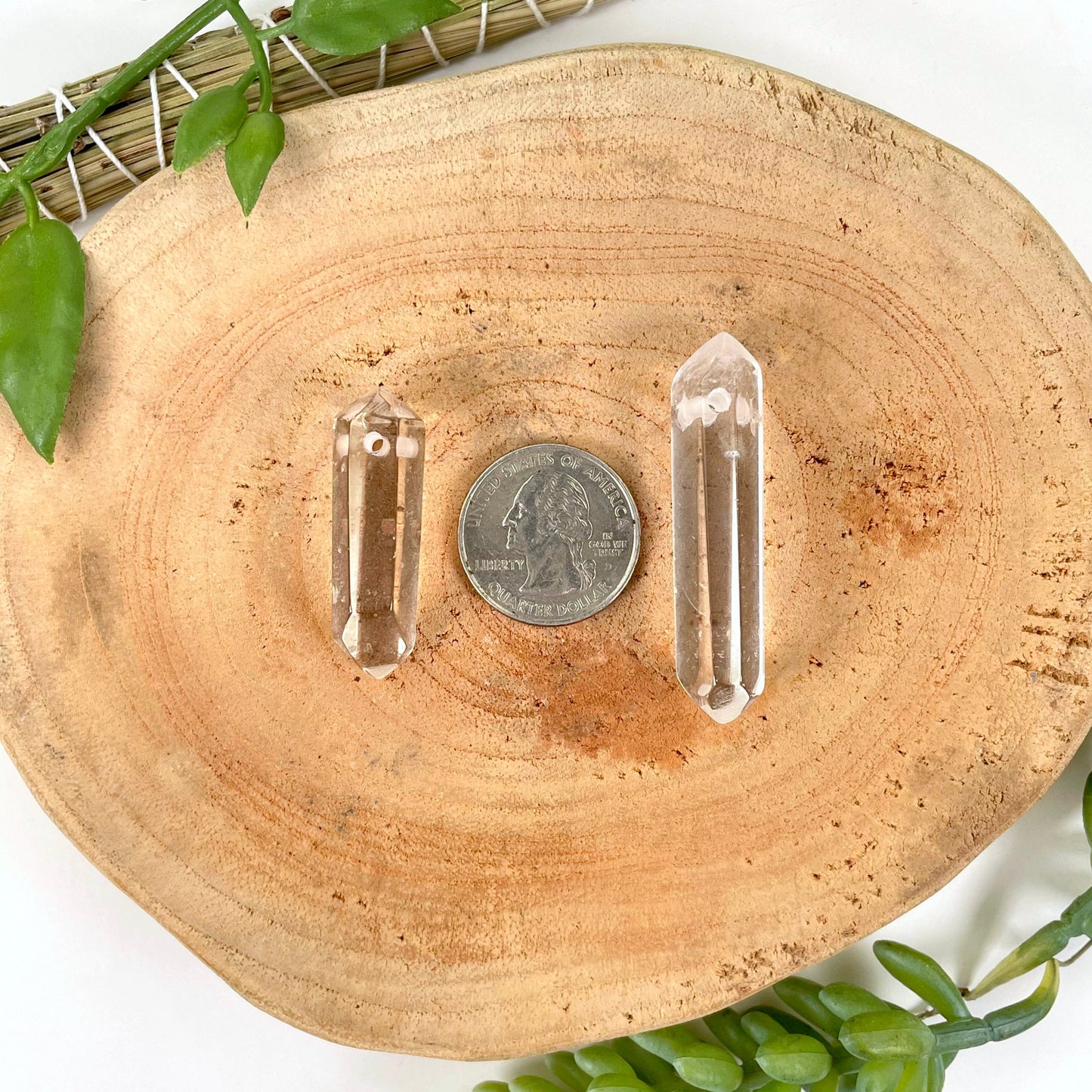 approximate largest and smallest drilled crystal quartz double points with quarter for size reference
