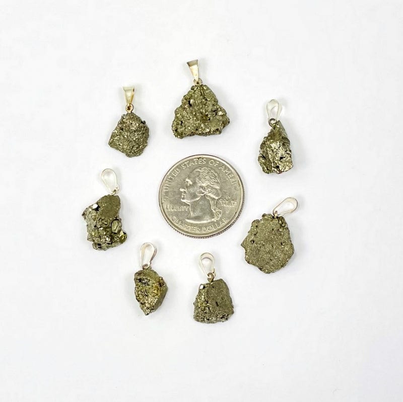 pyrite pendant with silver bail next to a quarter for size reference