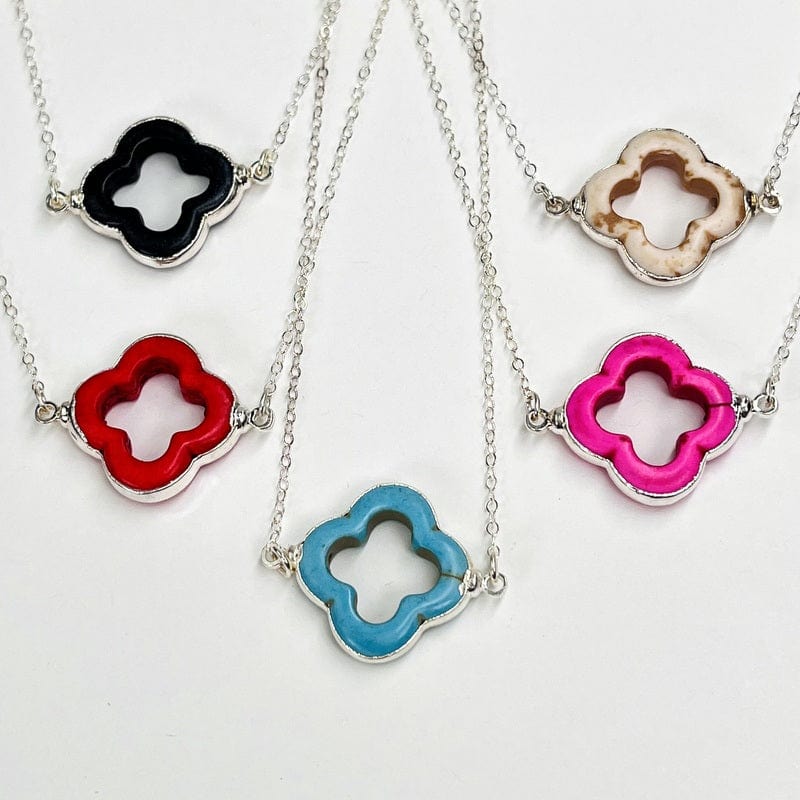 multiple clover necklacces displayed next to each other to show the differences in the colors