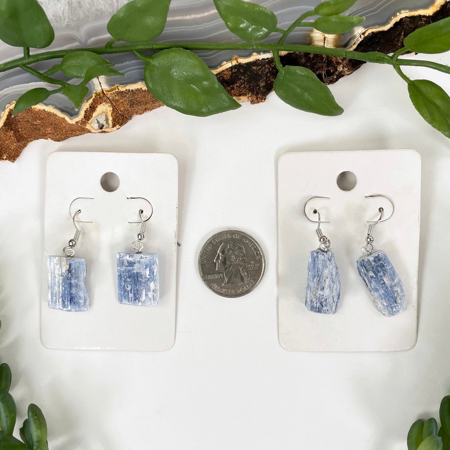 overhead view of two blue kyanite earring pairs with a quarter for size reference
