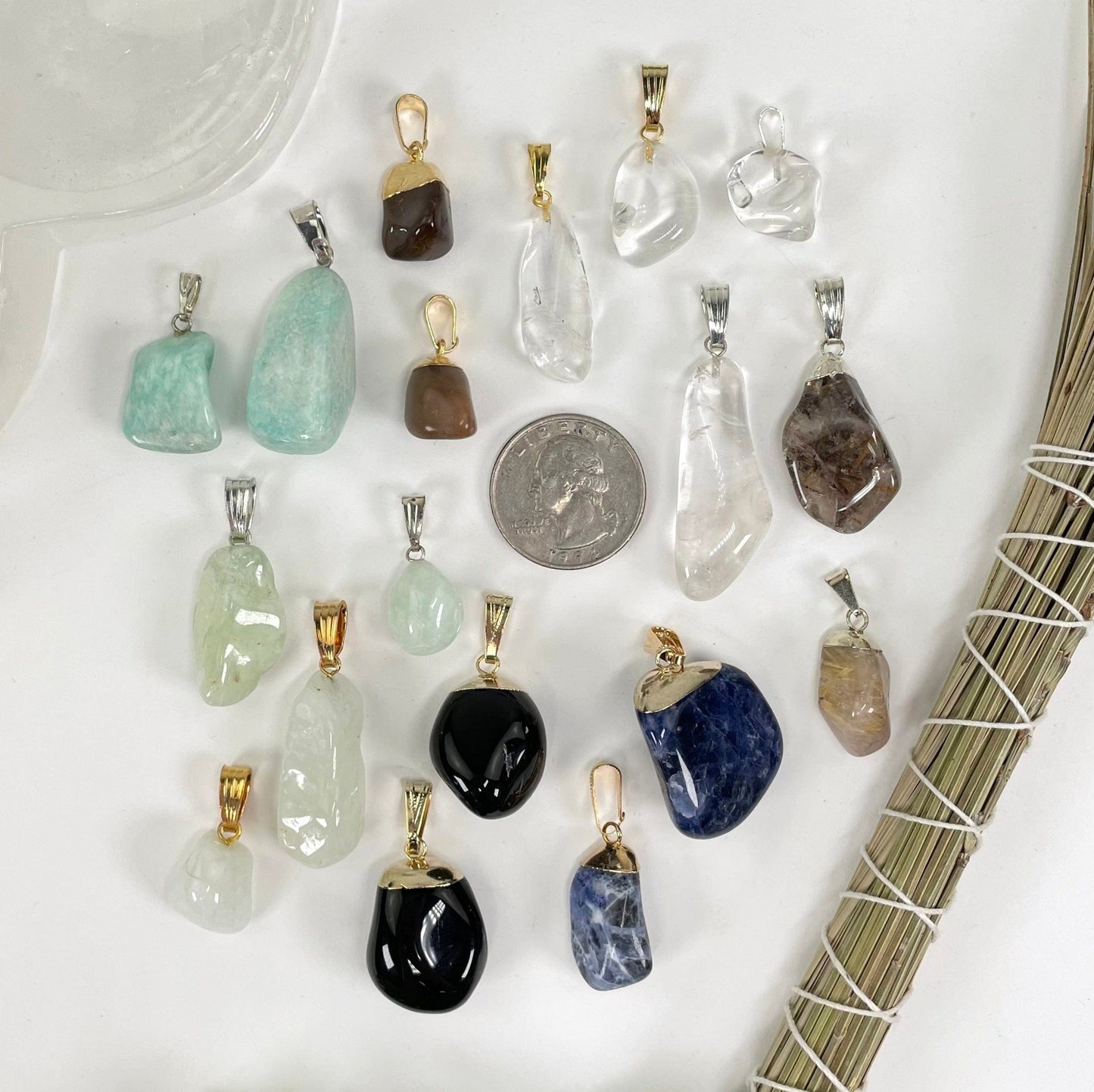 overhead view of two of each tumbled gemstone pendant options with a quarter for size reference