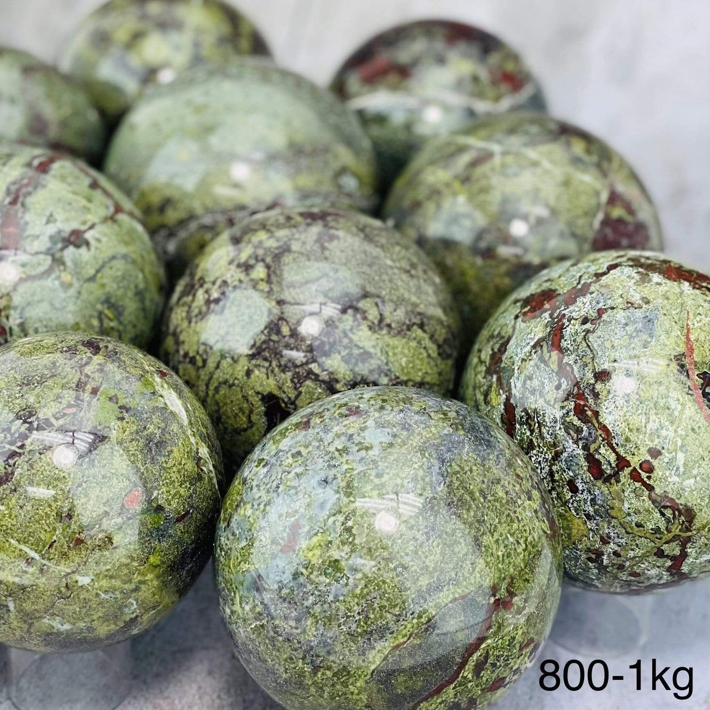 Close Up of Multiples Dragon Blood Stone Spheres on Gray Background.