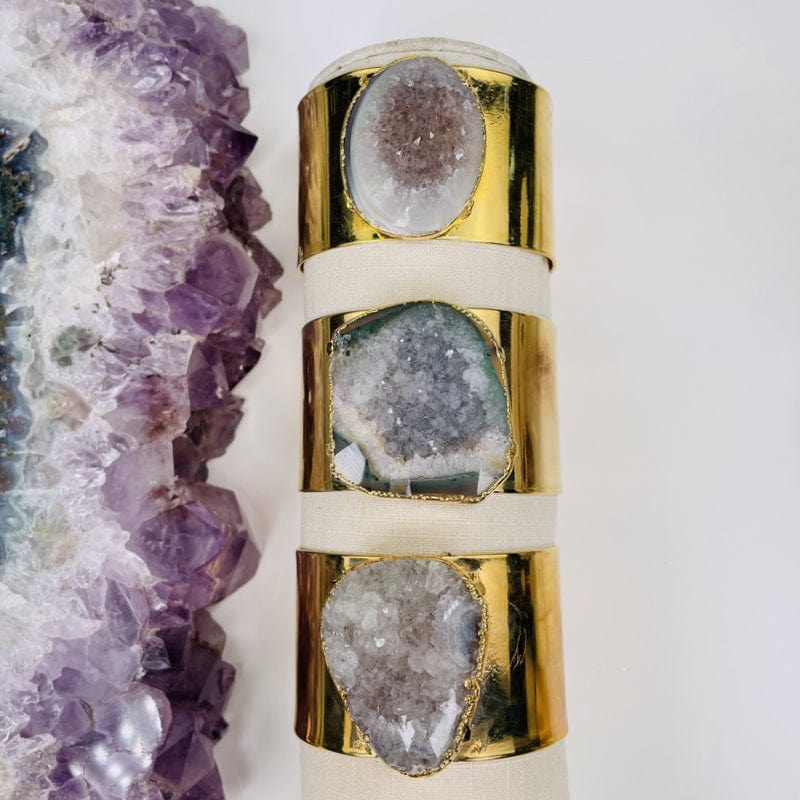 multiple amethyst cuff bracelets displayed to show the differences in the drusy