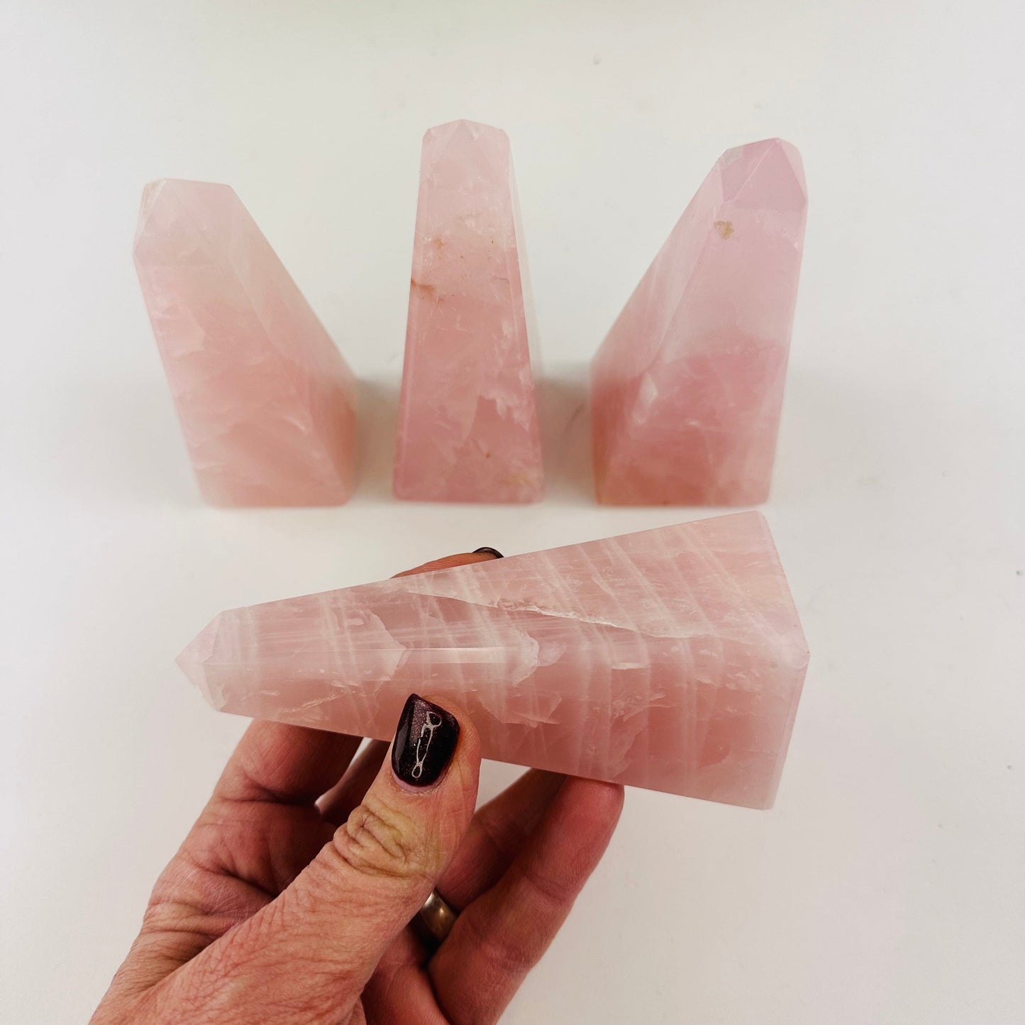 Rose Quartz Polished Obelisk Tower Bulk Lot of 4 showing side view in a hand for size reference