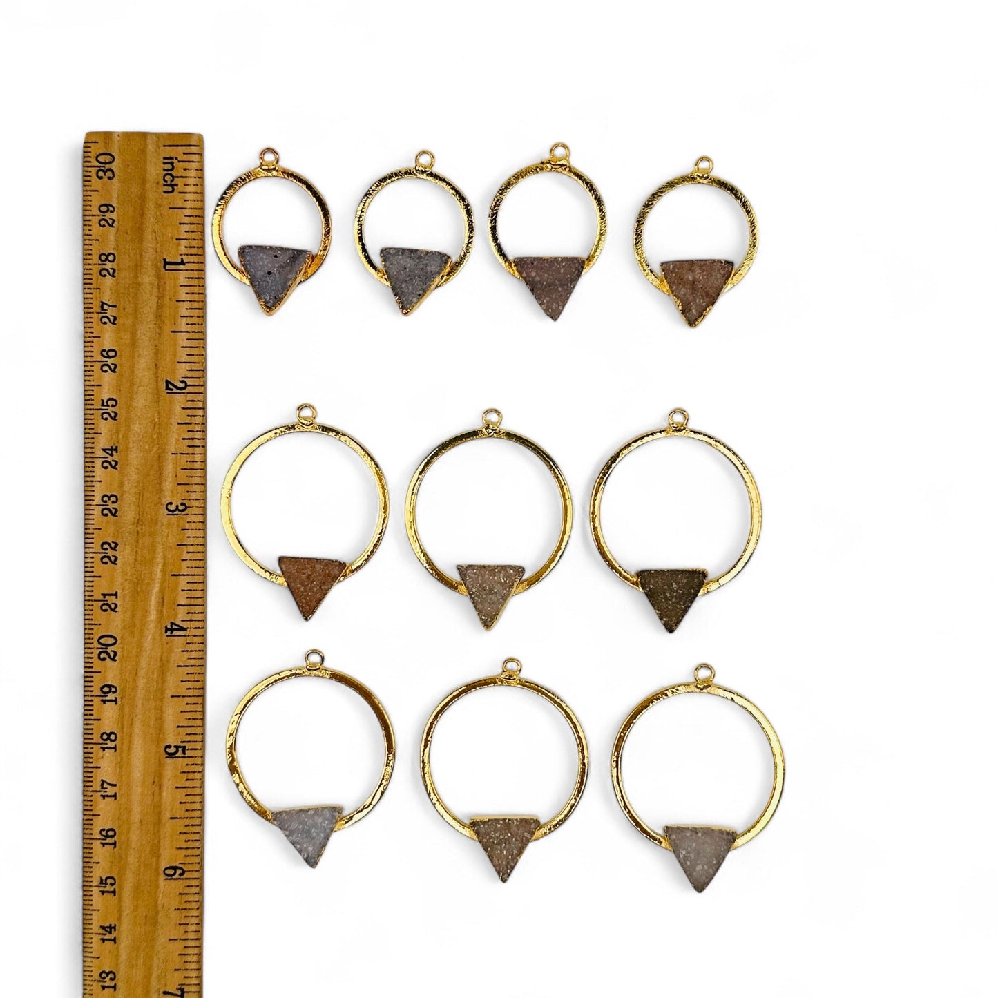pendants next to a ruler for size reference