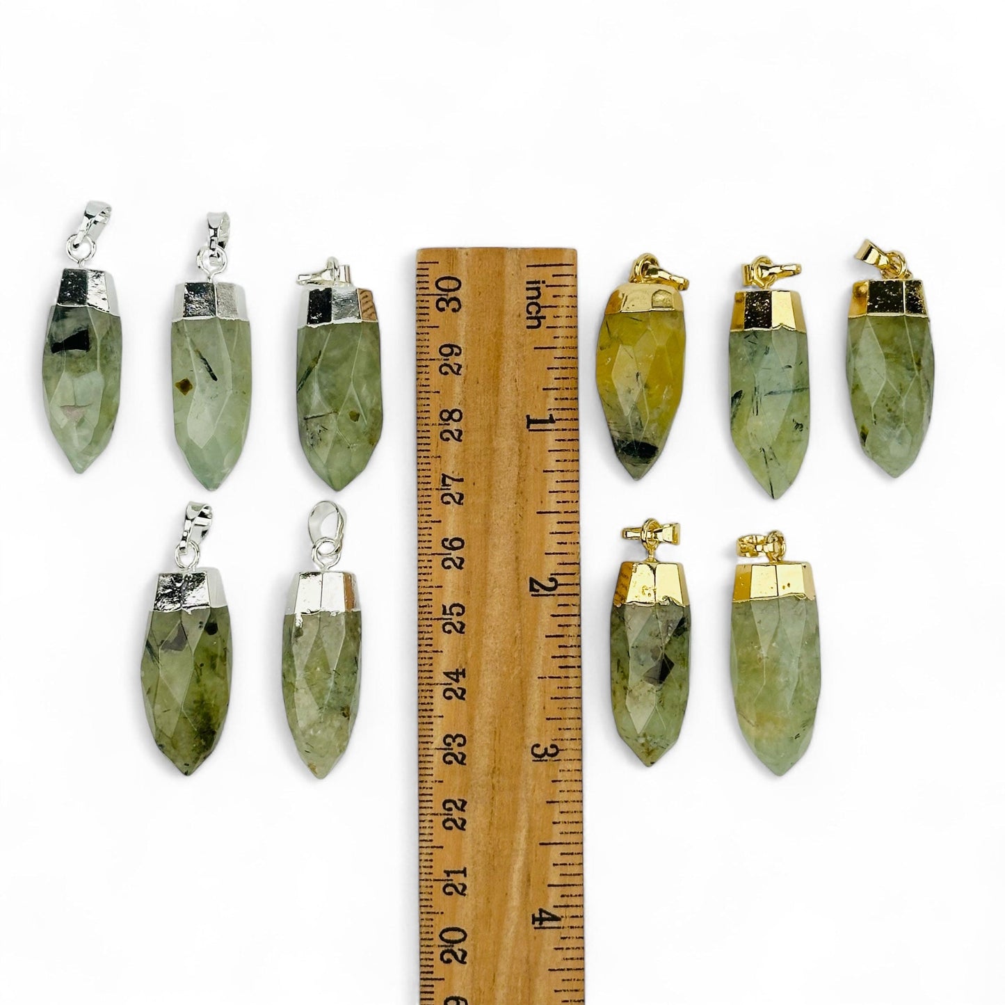 prehnite pendants displayed next to a ruler for size reference