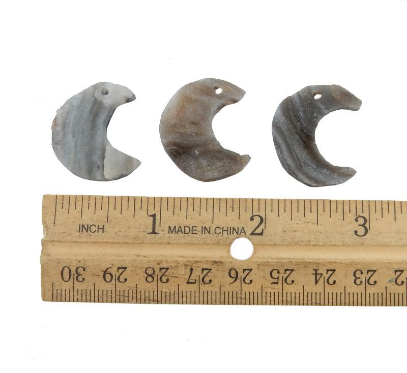3 Raw Chalcedony Moon Crescents lined up next to ruler for size reference on white background