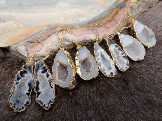 Multiple agate geode druzy dangle earrings displayed front facing.