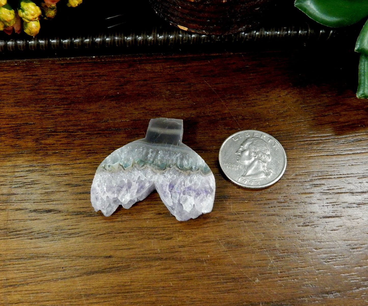 amethyst mermaid tail shaped bead next to a quarter for size reference