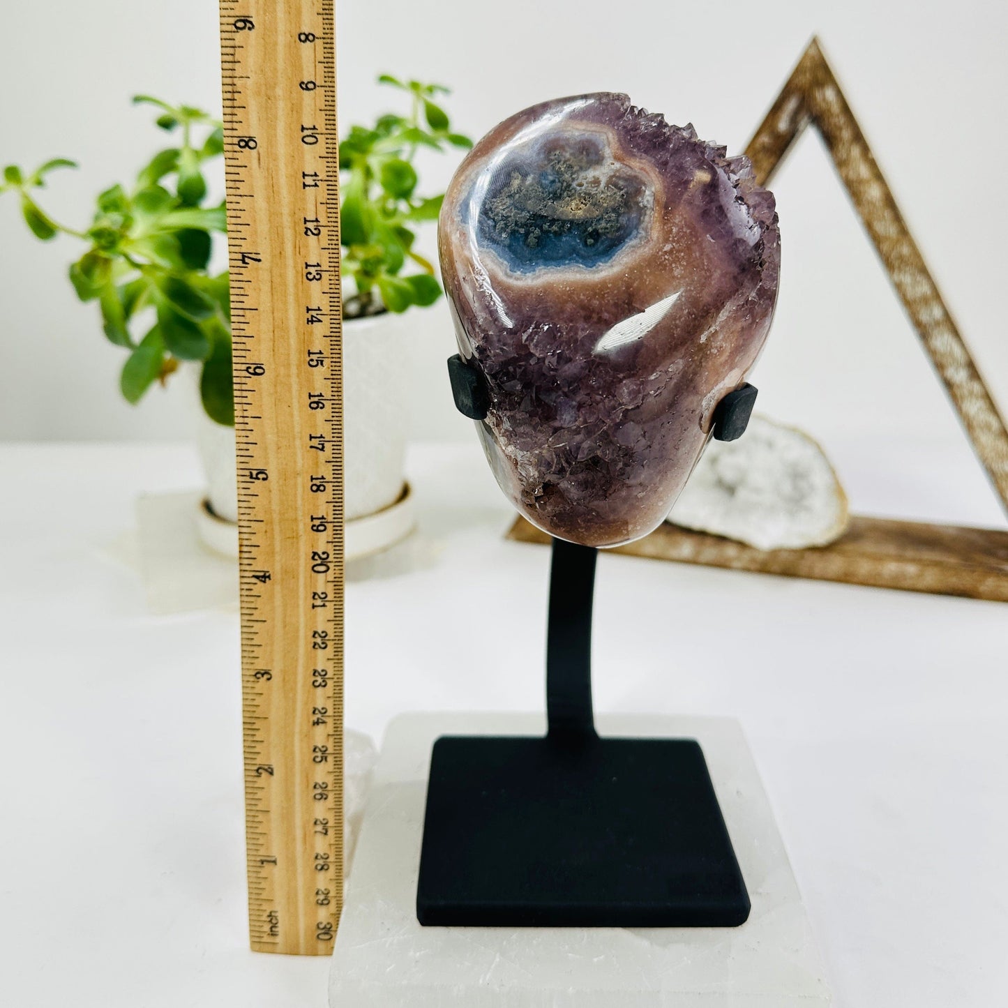 amethyst on metal stand next to a ruler for size reference