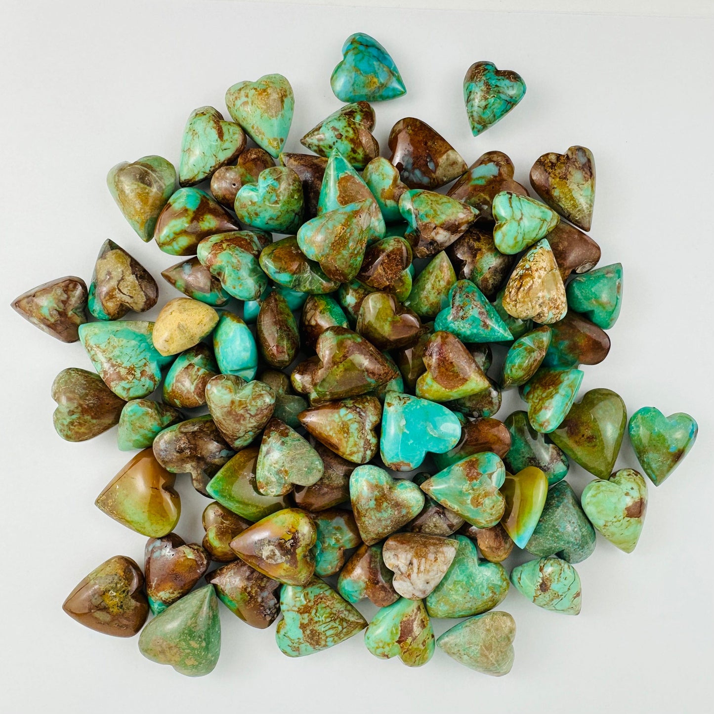 Turquoise Hearts in a pile on a white table
