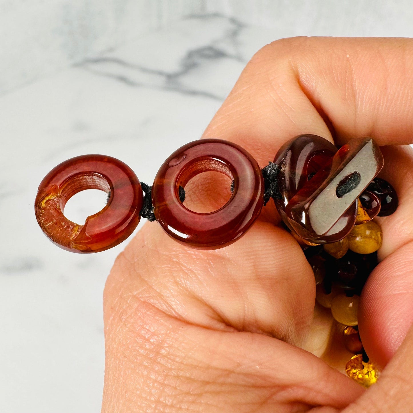 Up close view of minor chip on last amber hoop of necklace option B.