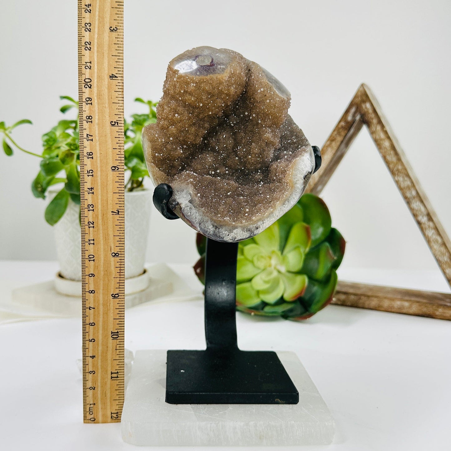 amethyst on metal stand next to a ruler for size reference