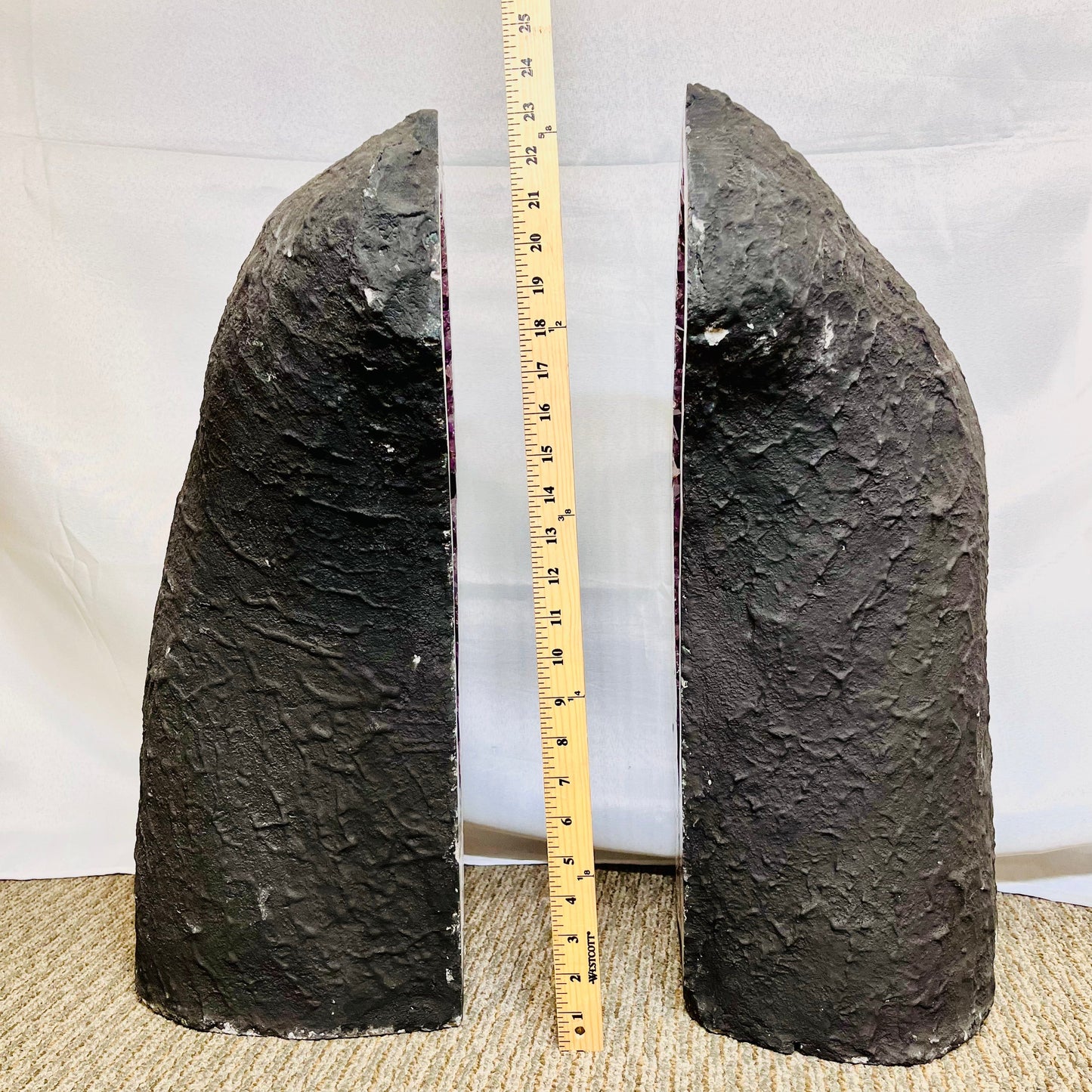 Profile view of each of the Large Amethyst Sliced Geode Wings, facing each other and an upright yard stick placed in between them for size reference.