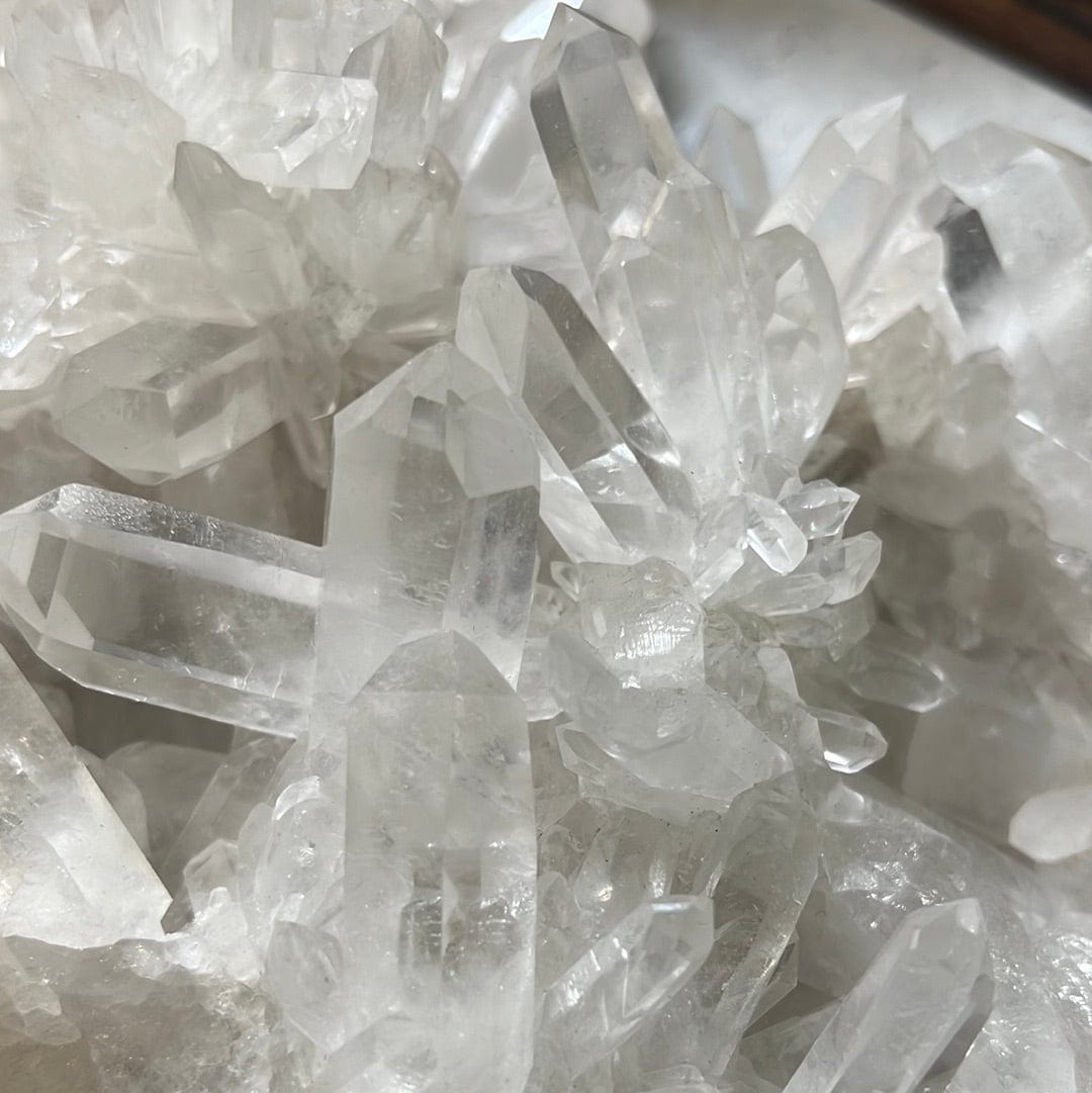 close up of Large crystal cluster with points all over it on a cement background.