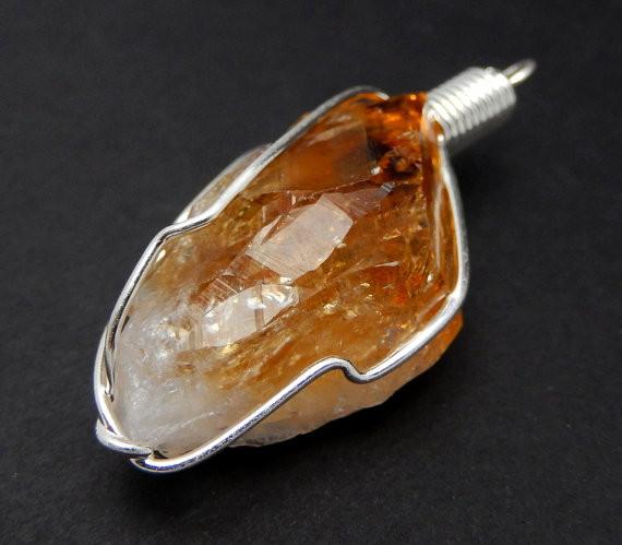 close up of the details on this citrine pendant with silver wire wrapping