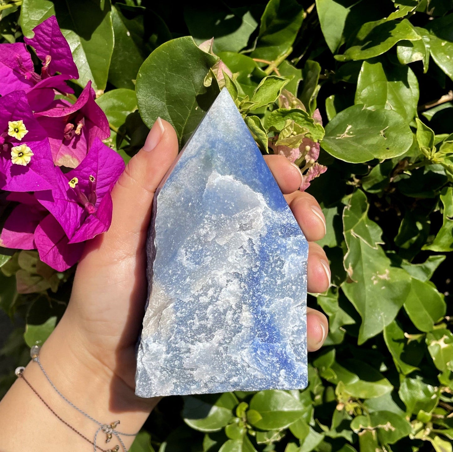 blue quartz polished point in hand 