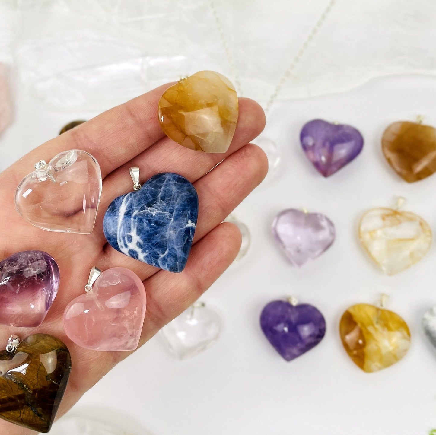 stone hearts with silver bail in a hand