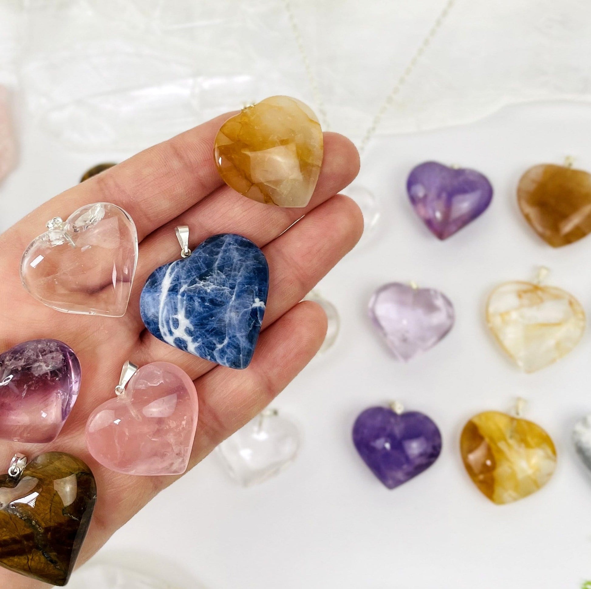 stone hearts with silver bail in a hand