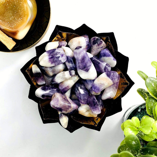 A gold bowl holding Chevron Amethyst Tumbled Gemstones