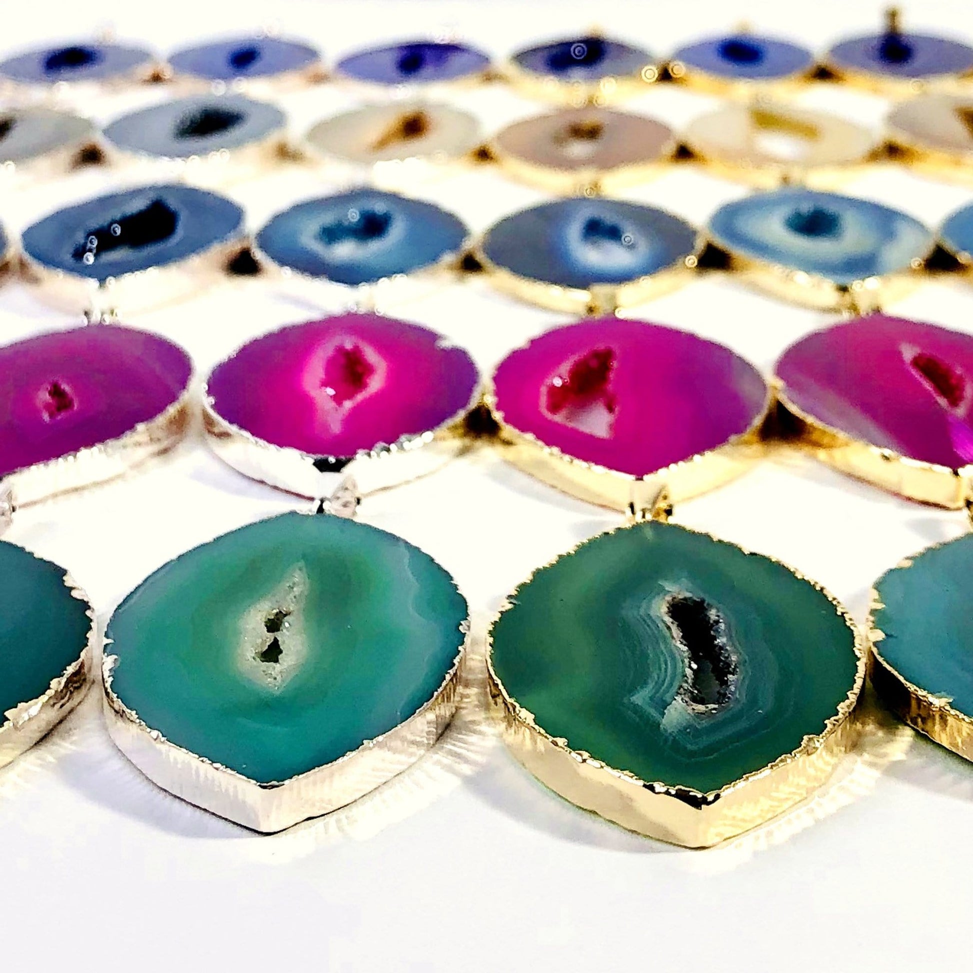  A close up angled view of agate druzy pendants marquise shape with a white background.